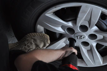 Mechanic using impact wrench on car wheel