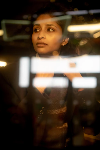 A woman looking out a window at night