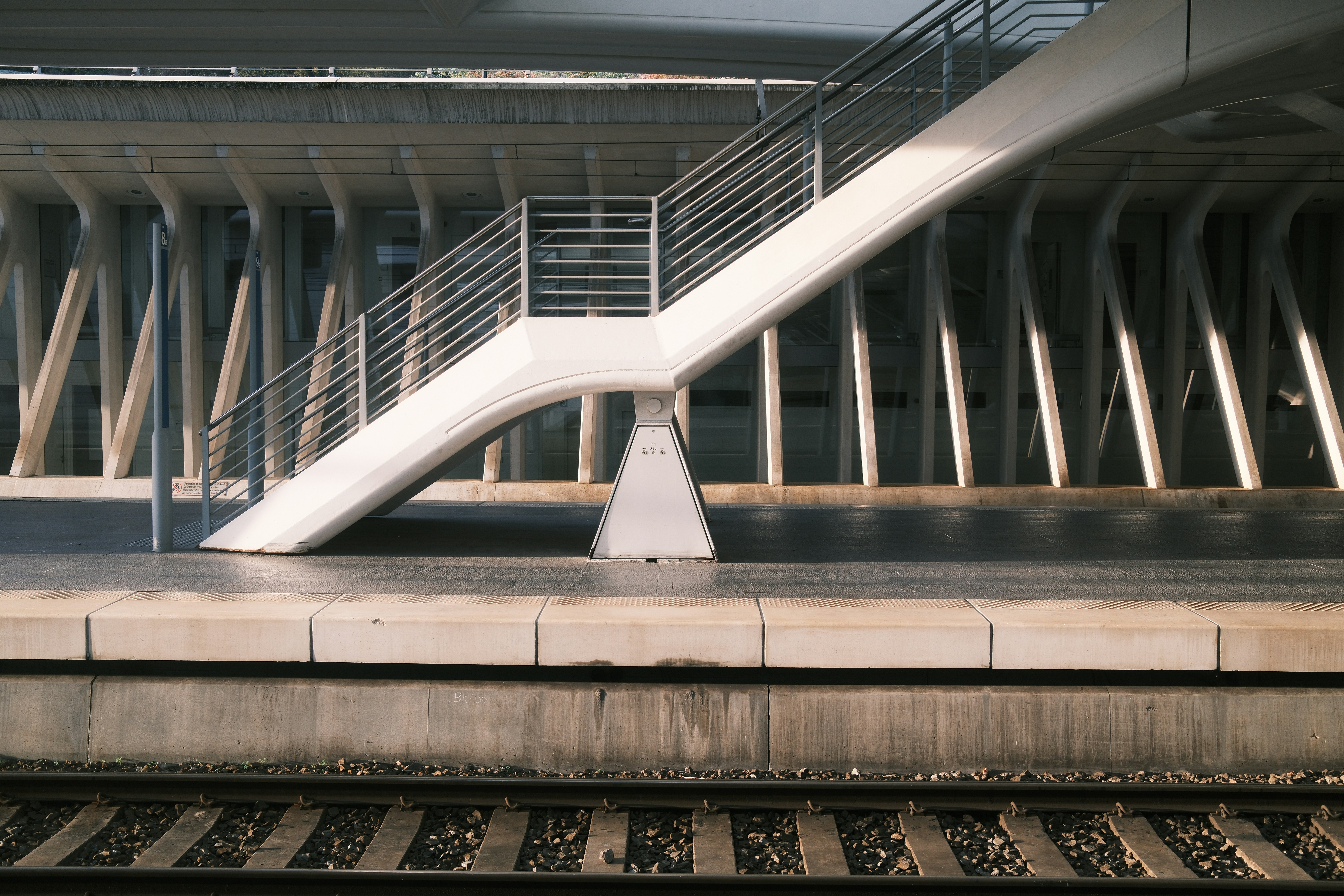 Modern train station with elevated walkway and tracks