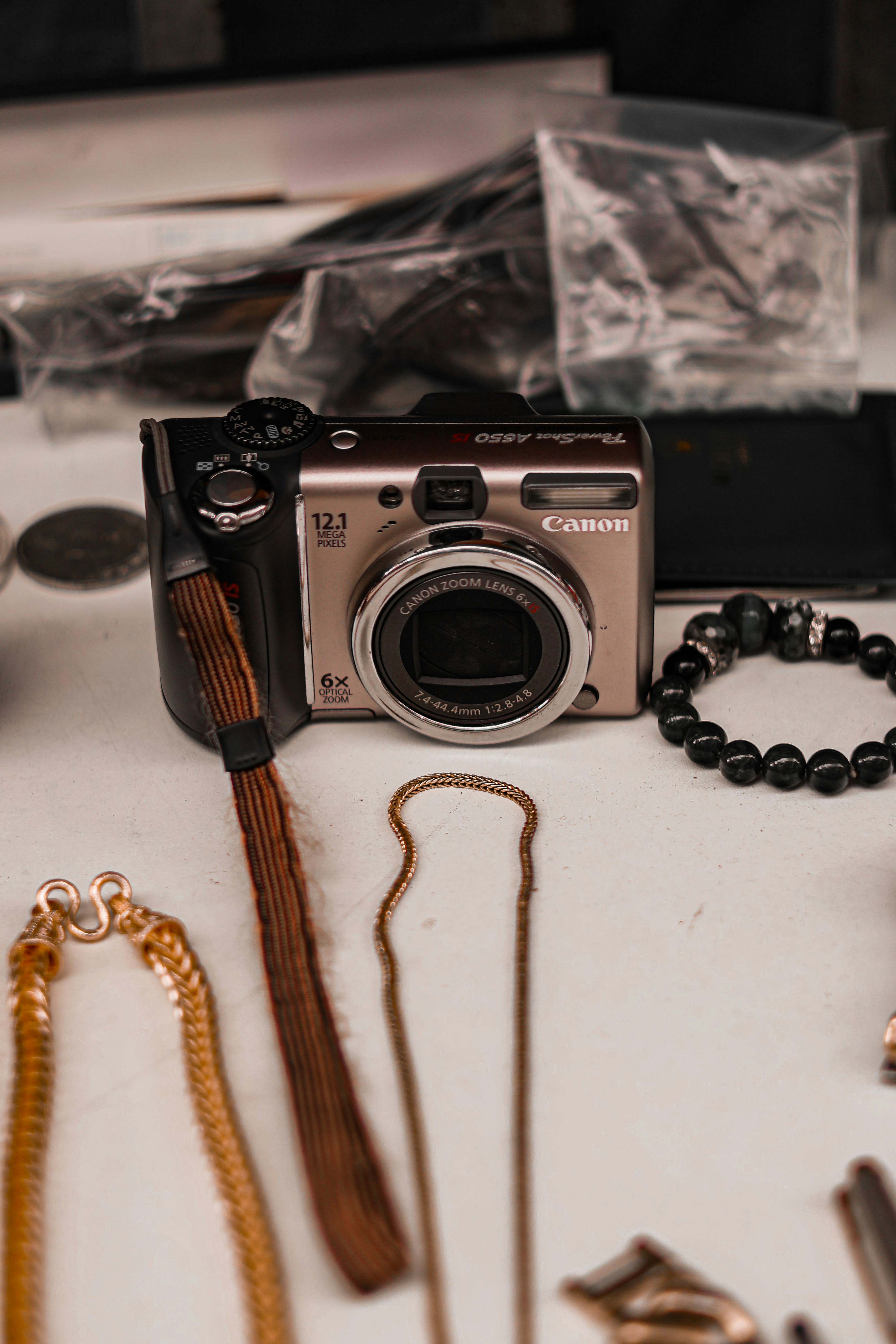 A digital camera surrounded by jewelry and accessories