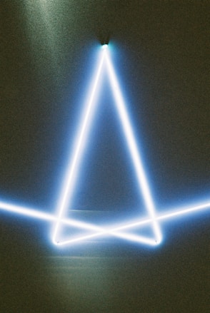 A glowing blue triangle on a dark background.