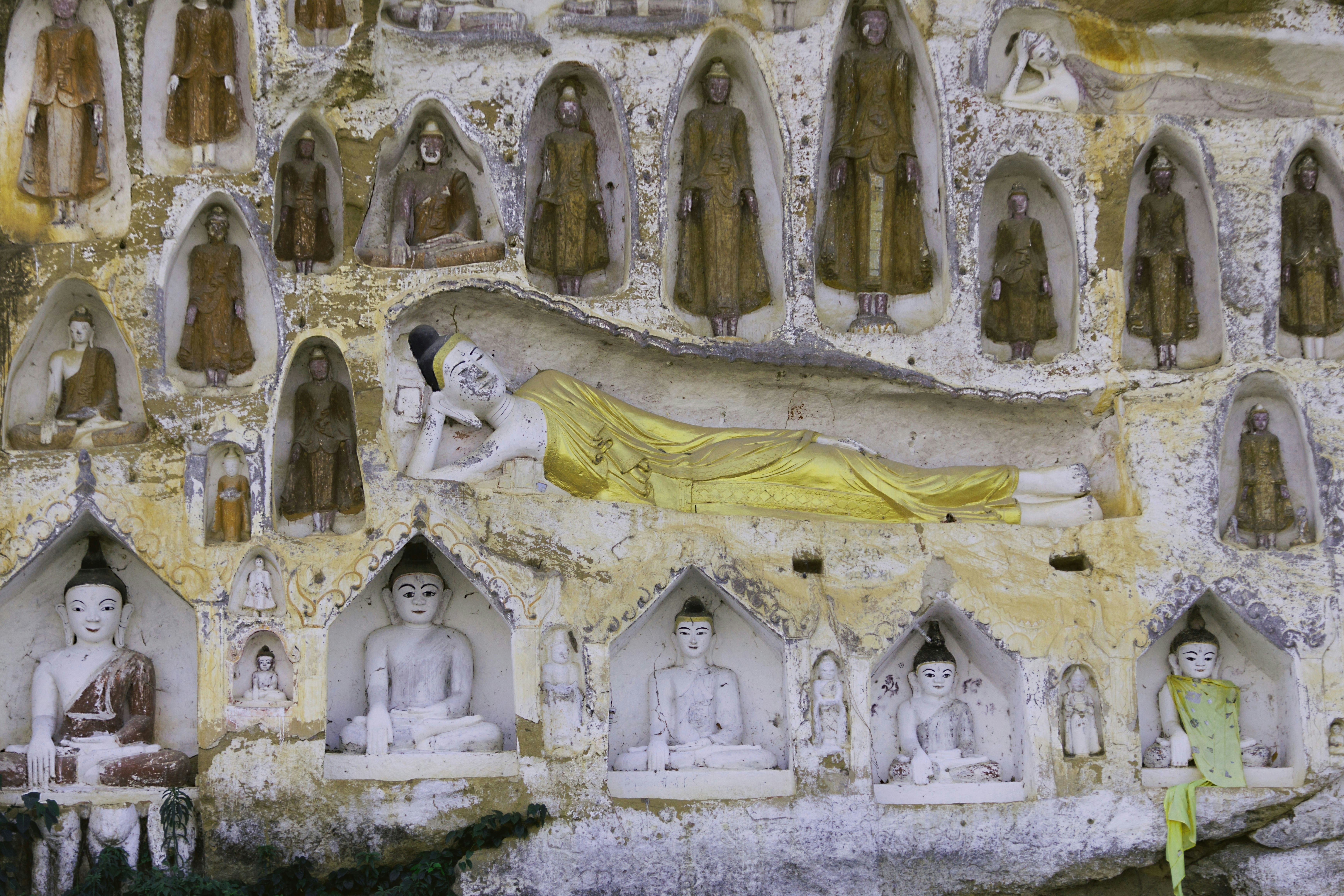 Reclining buddha statue surrounded by smaller statues.