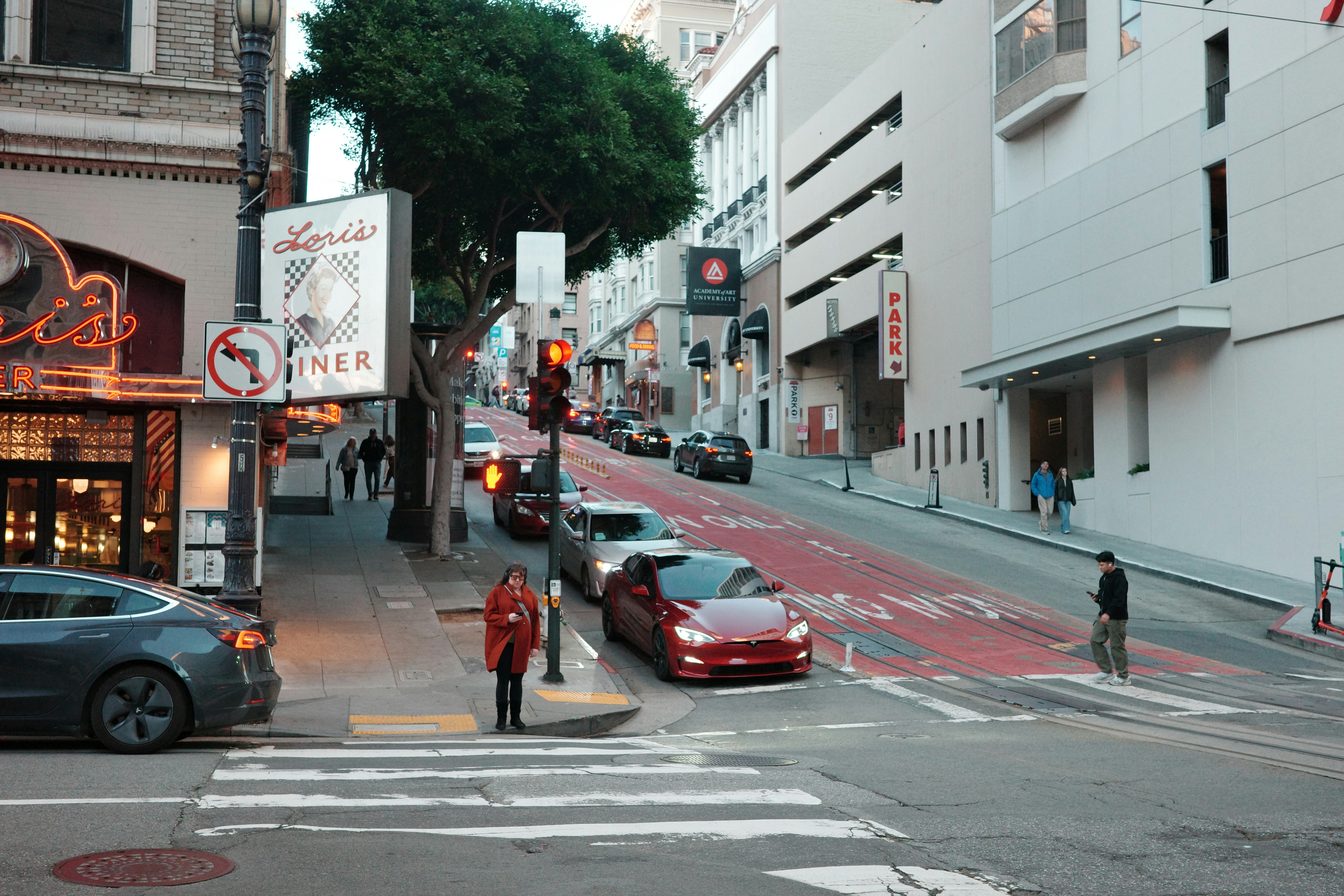 Cars parked on a steep, narrow city street.