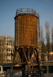 Tall wooden silo structure with metal ladder and platform