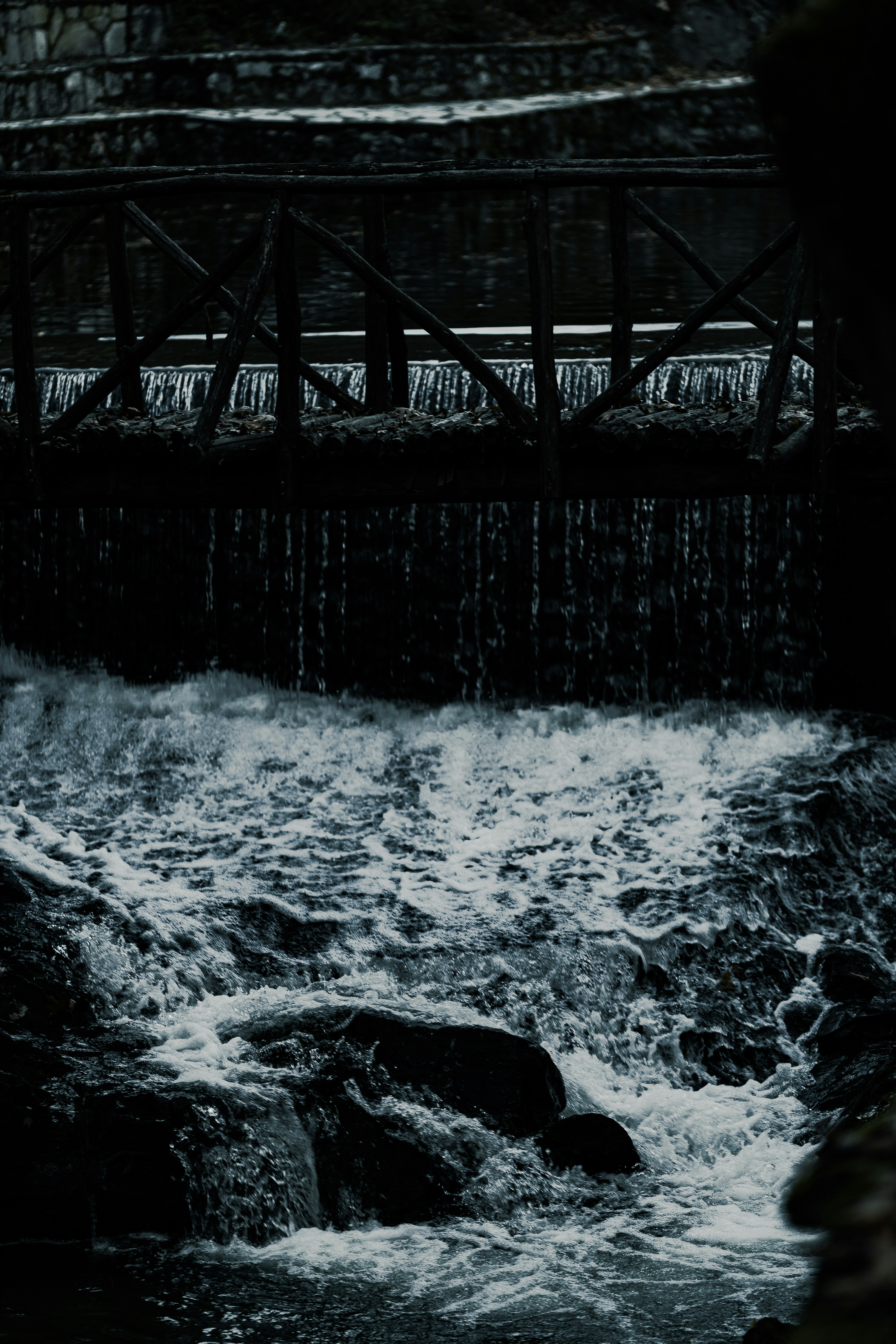Holzbrücke über einen rauschenden Wasserfall