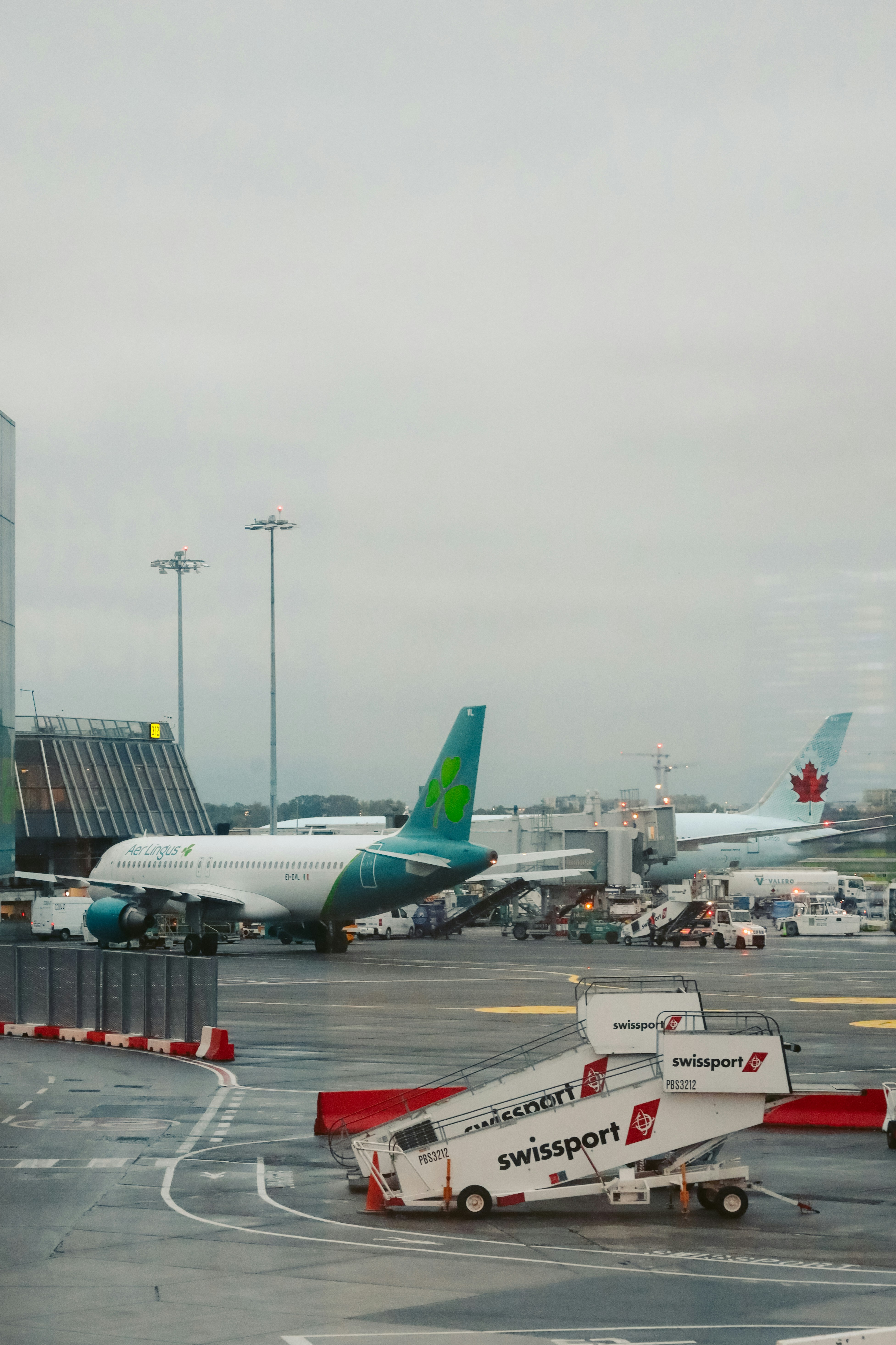 Airplanes at an airport tarmac with stairs.