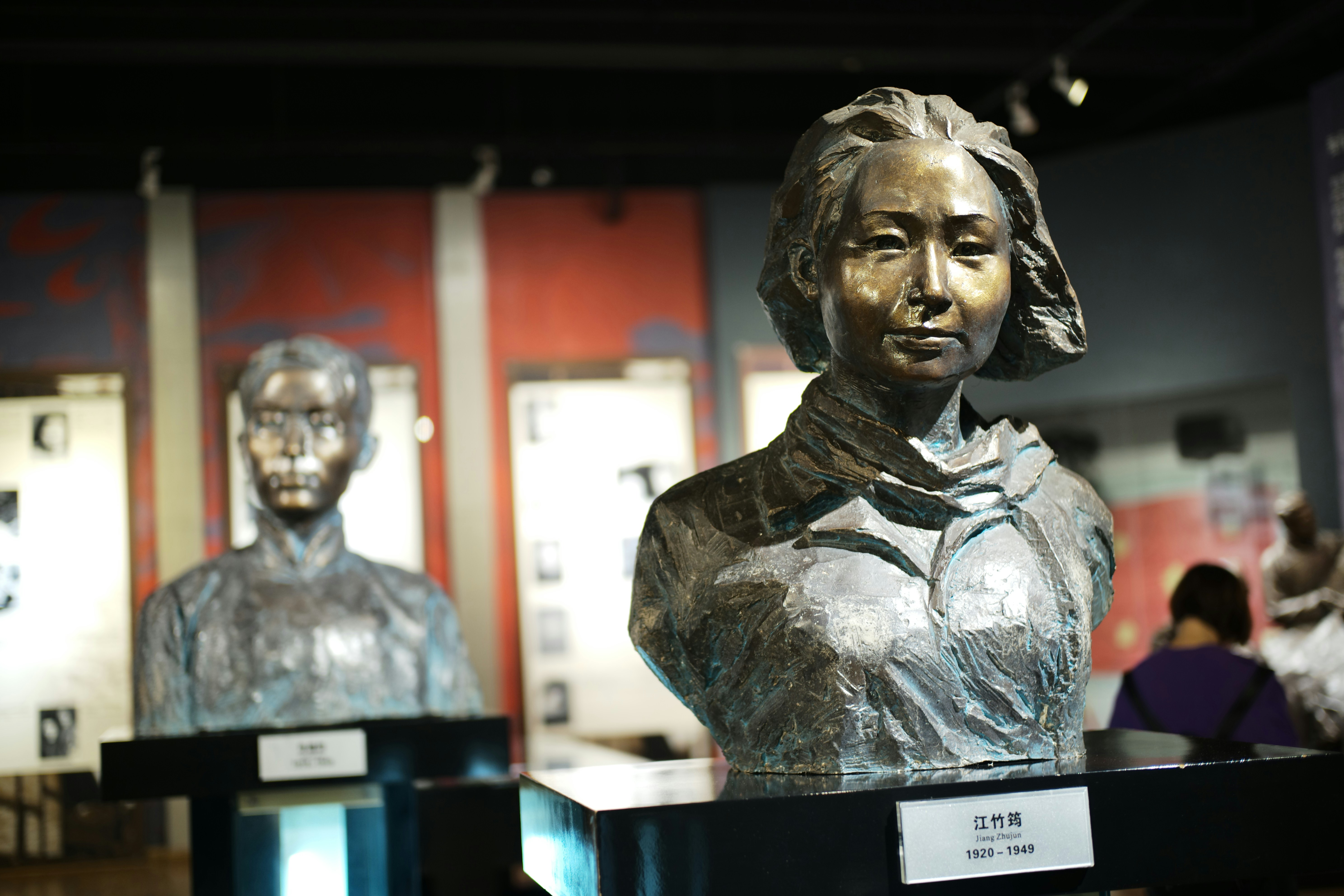 Two bronze busts displayed in a museum exhibit.