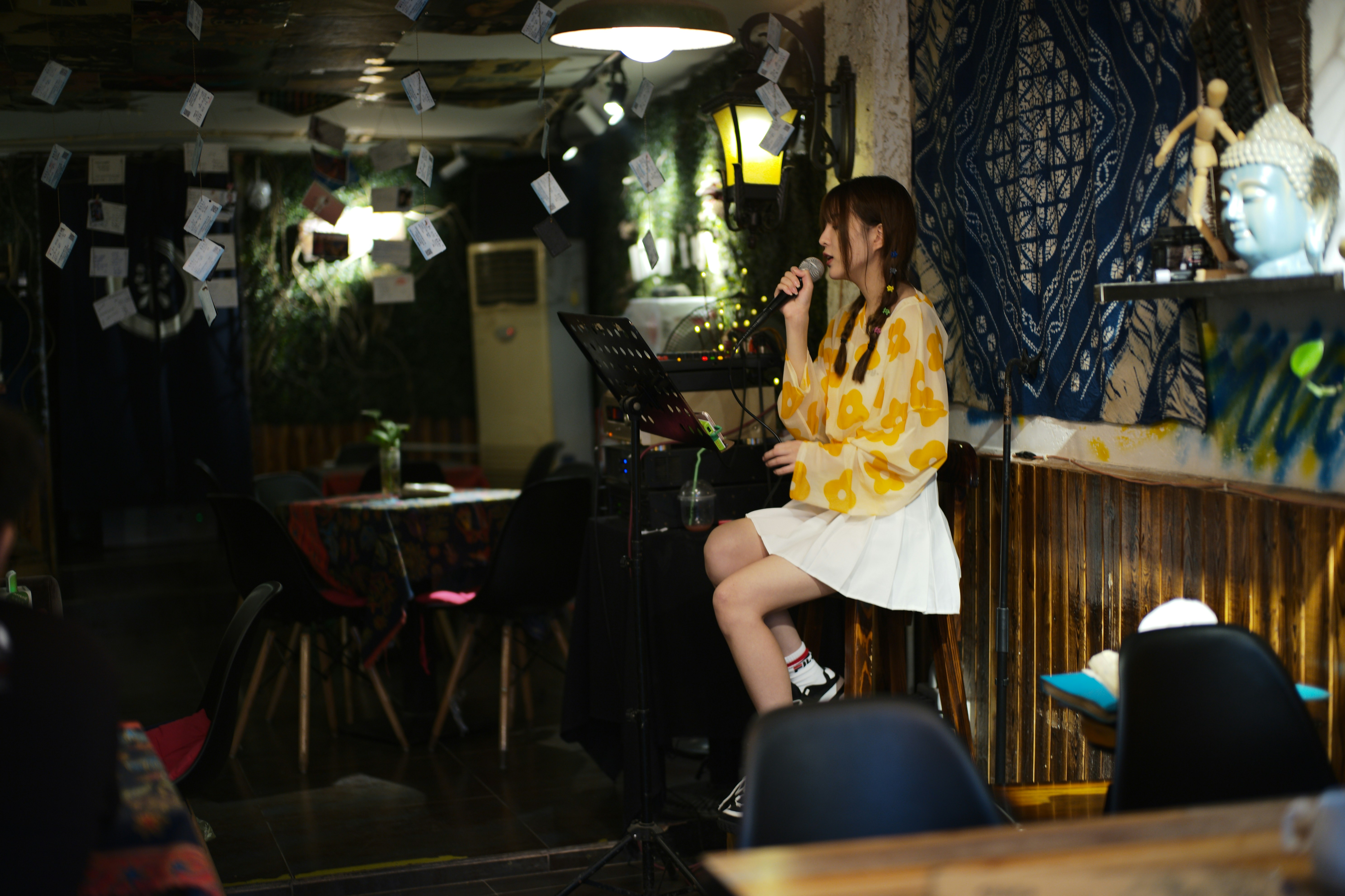 A woman sings into a microphone on stage.