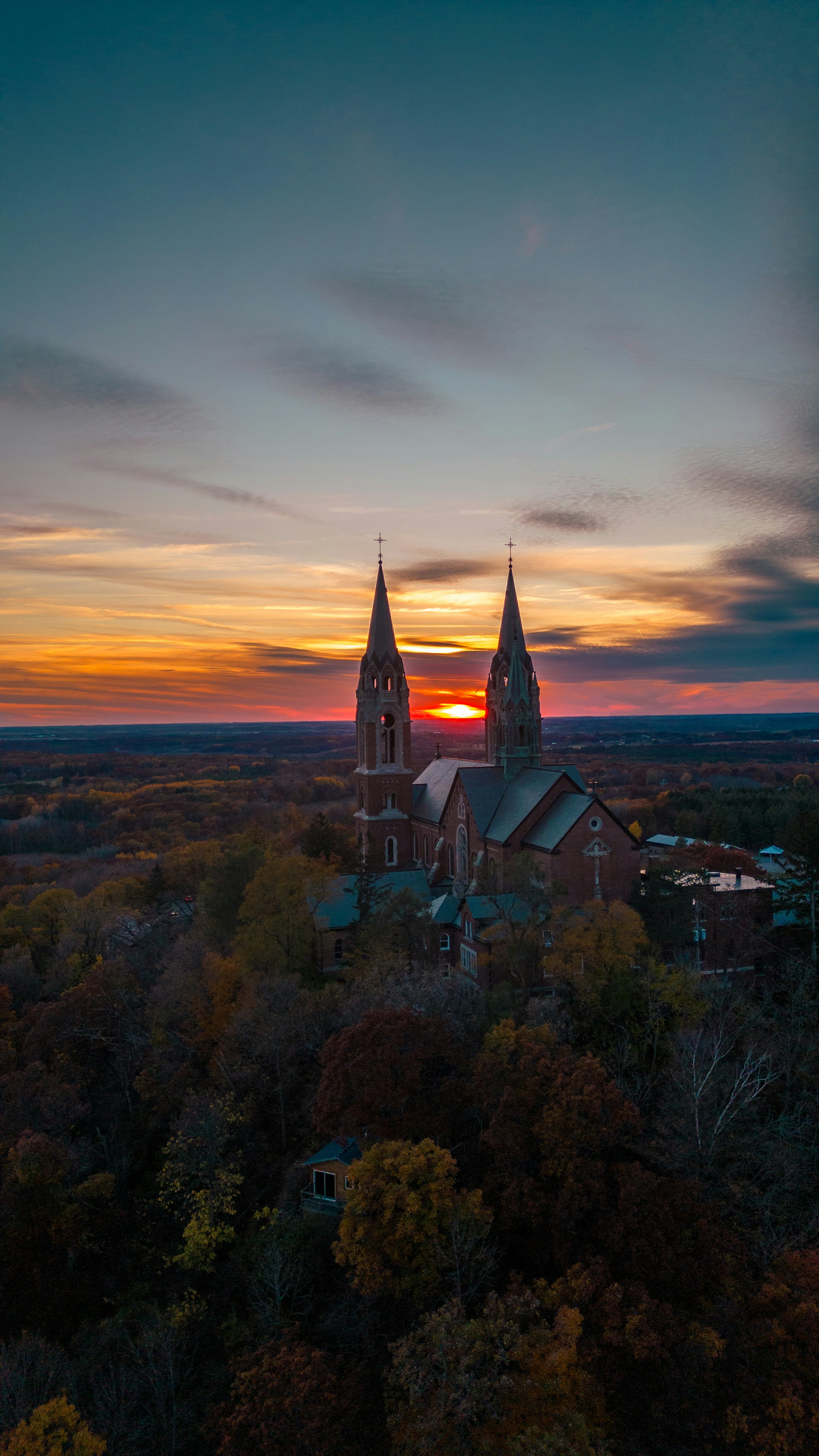 Church with spires at sunset over autumn trees