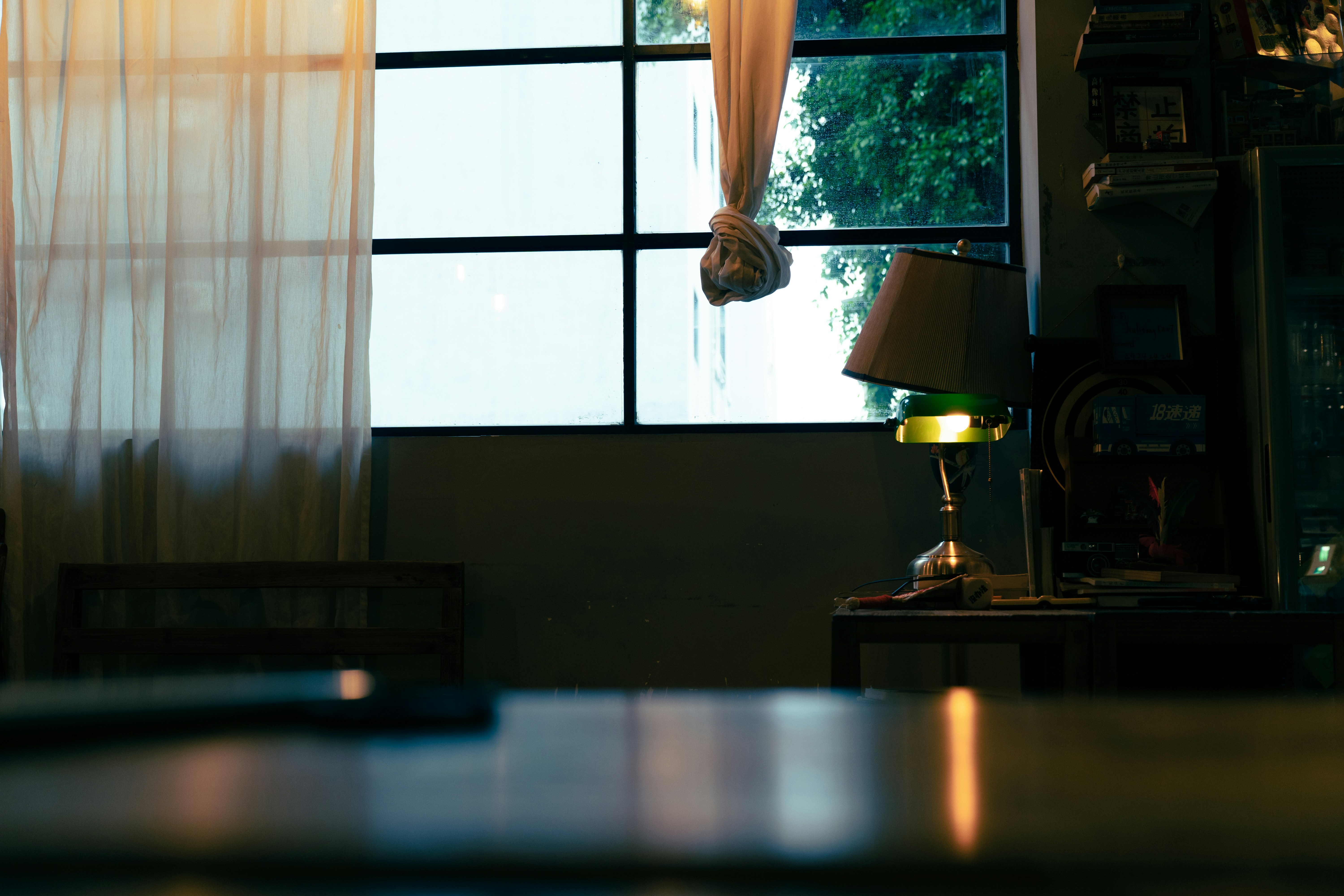 Desk lamp with green shade near window