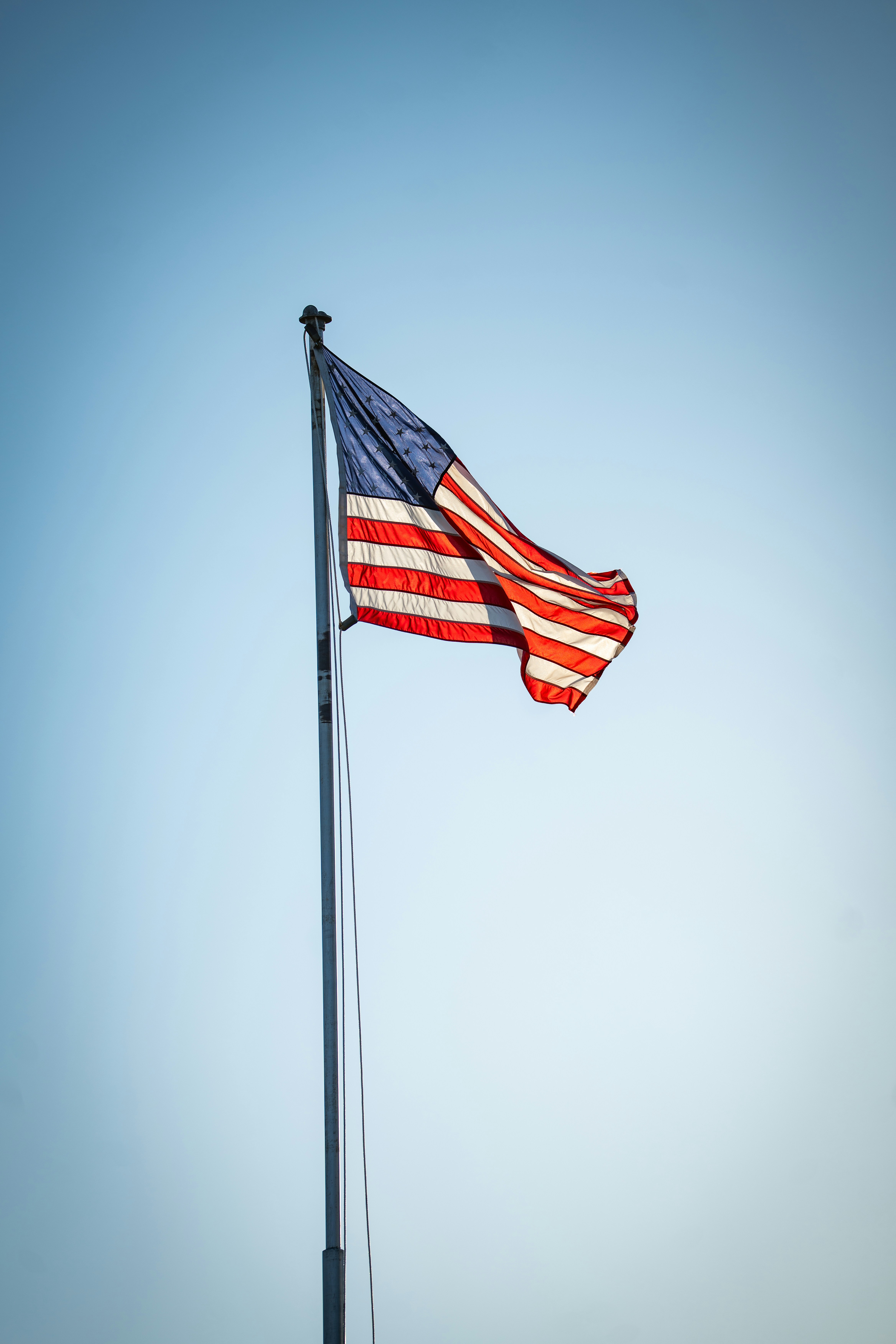 American flag waving against a clear blue sky