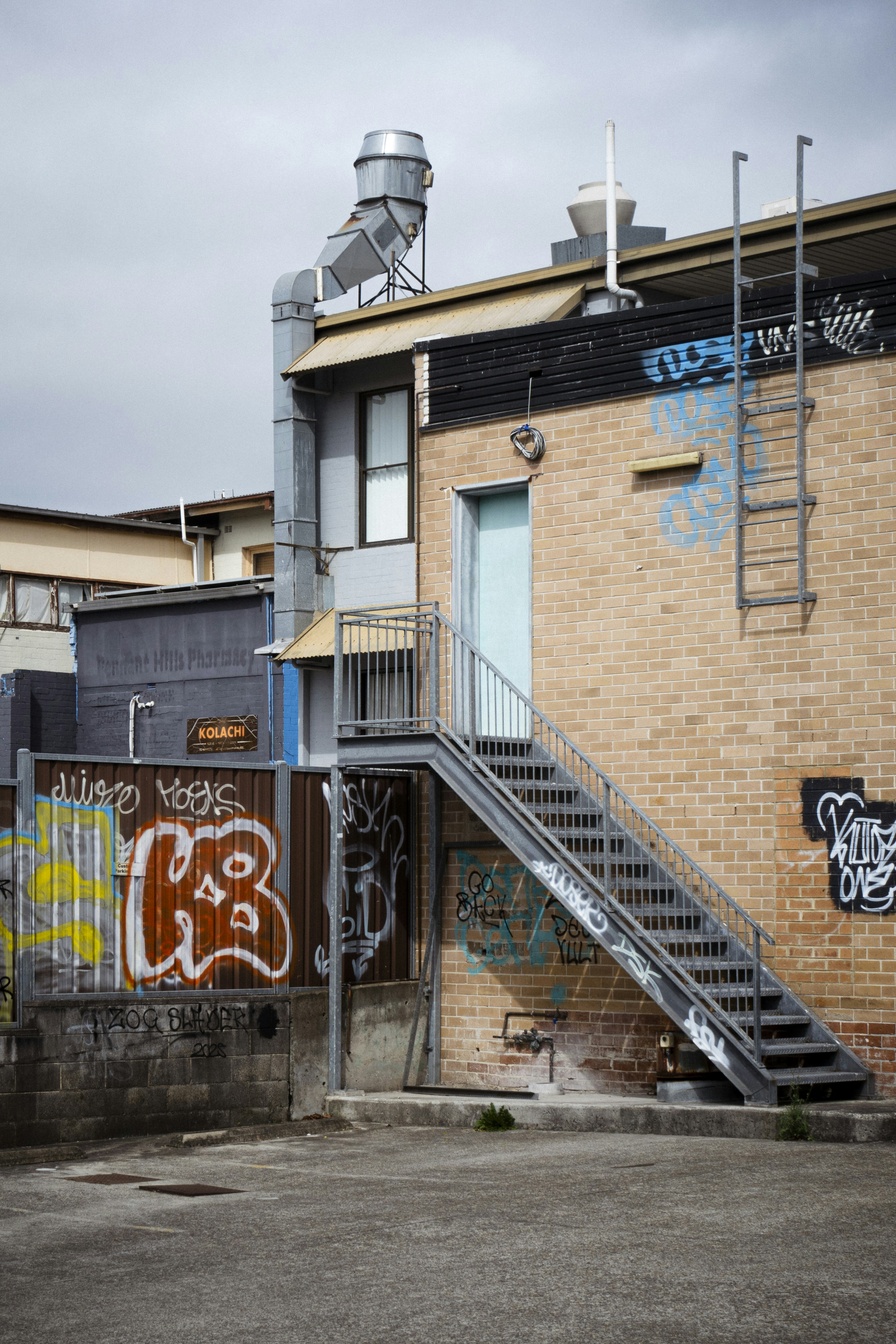 Exterior metal staircase on brick building with graffiti