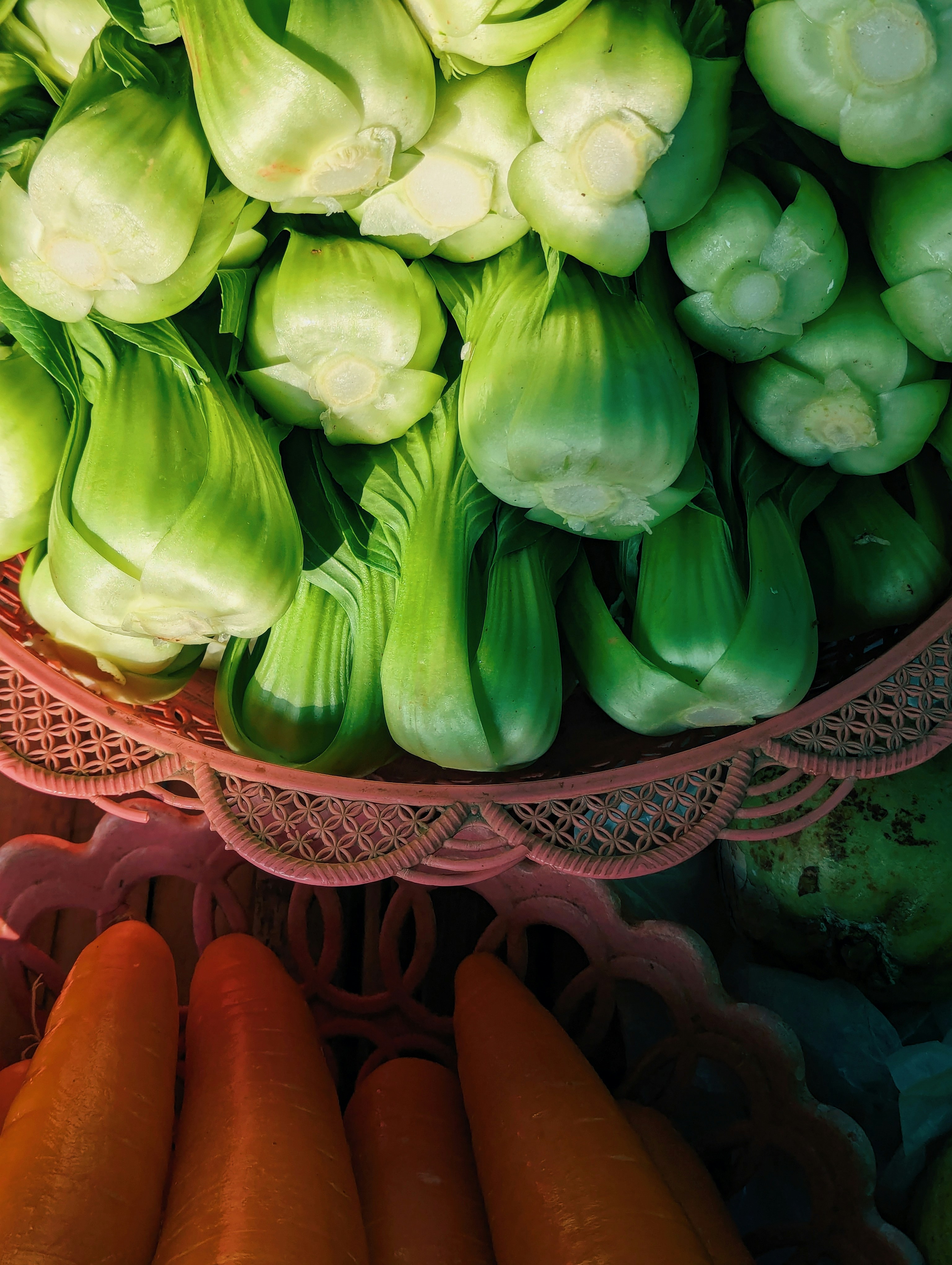 Fresh bok choy and carrots in baskets