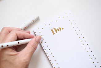 Hand writing on a do list with gold polka dots.