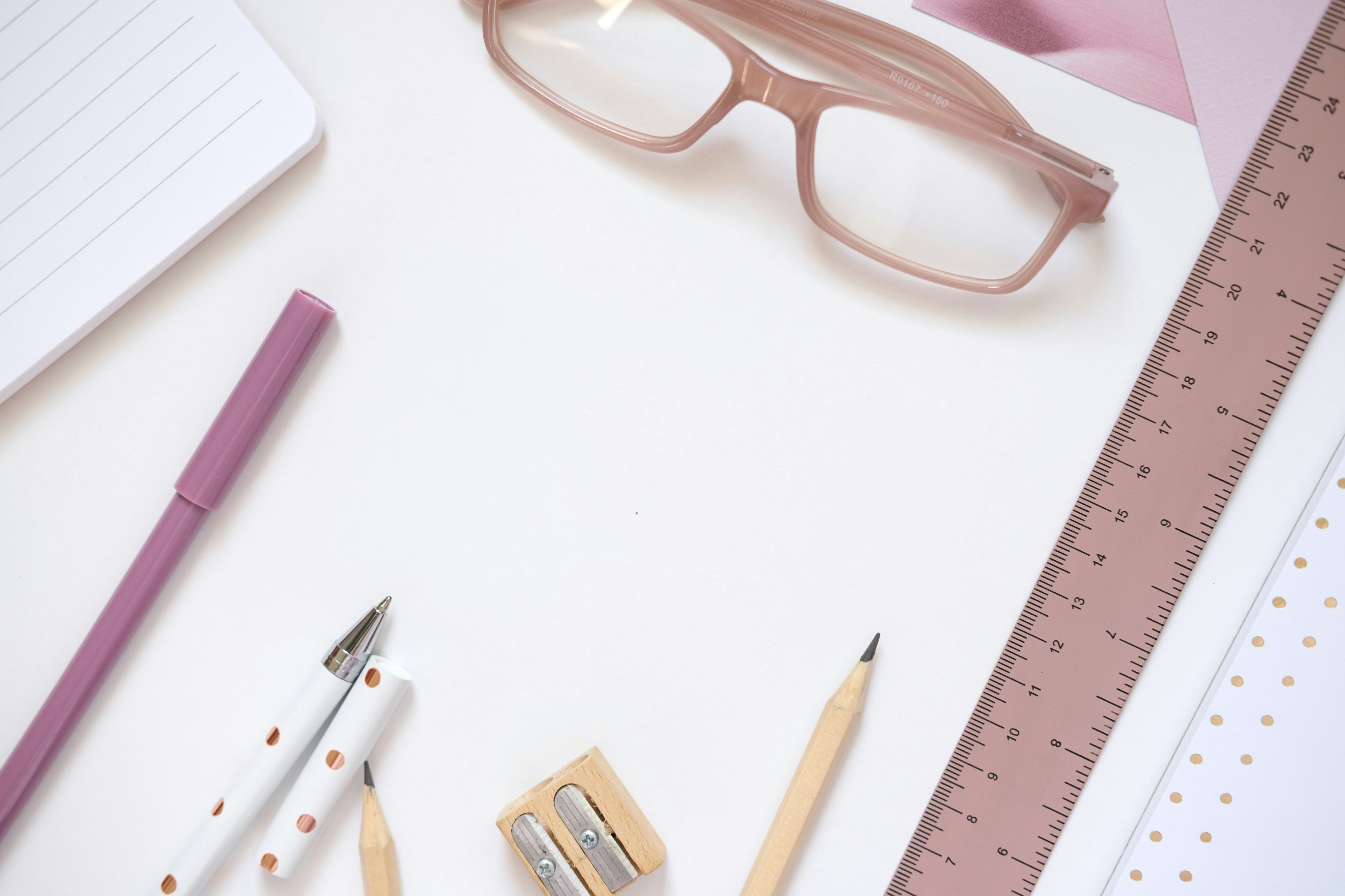 Desk accessories including glasses, ruler, and pens.