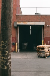 Warehouse loading dock with stacked wooden pallets.