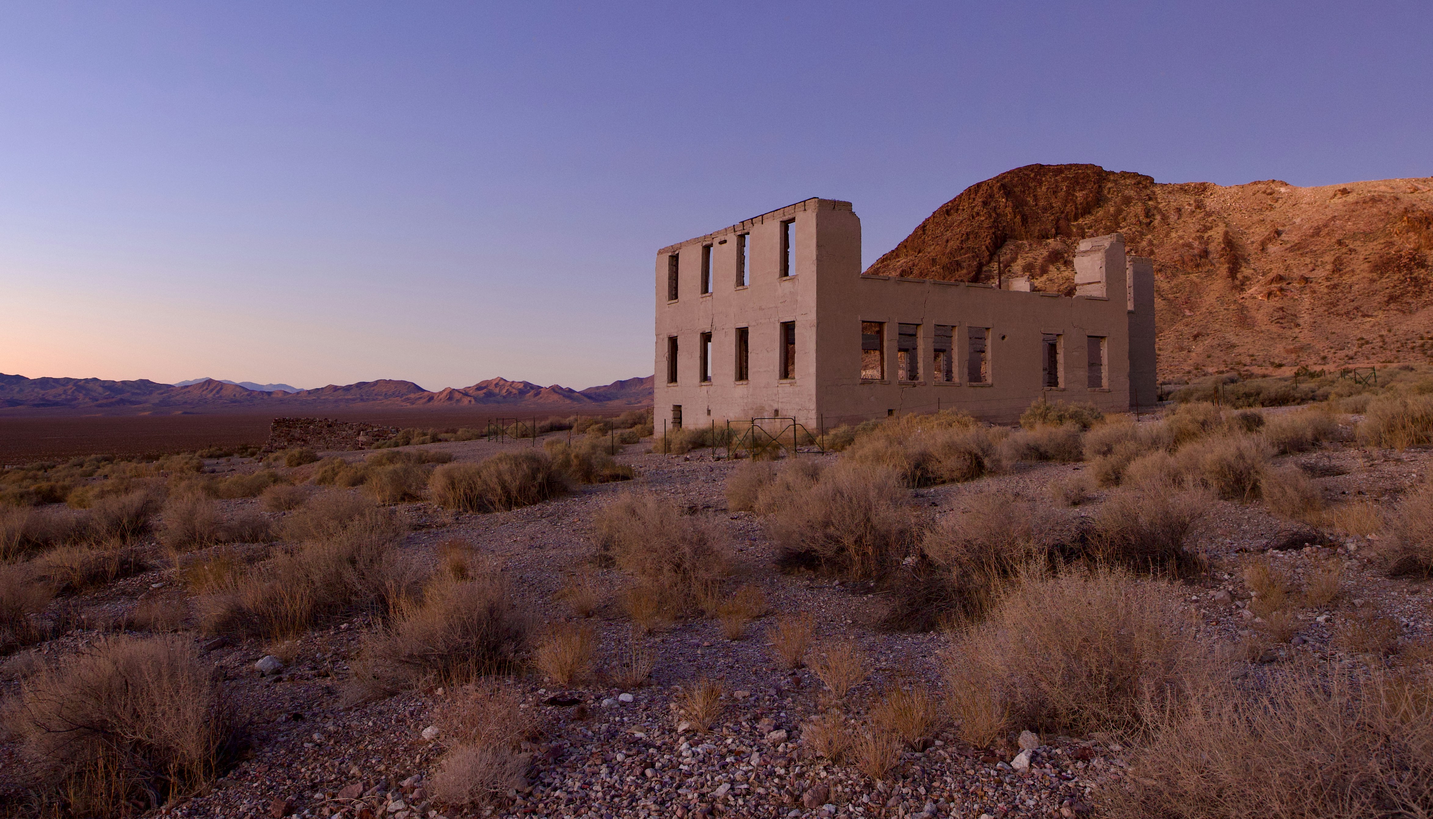 Abandoned building in a desert landscape at sunset