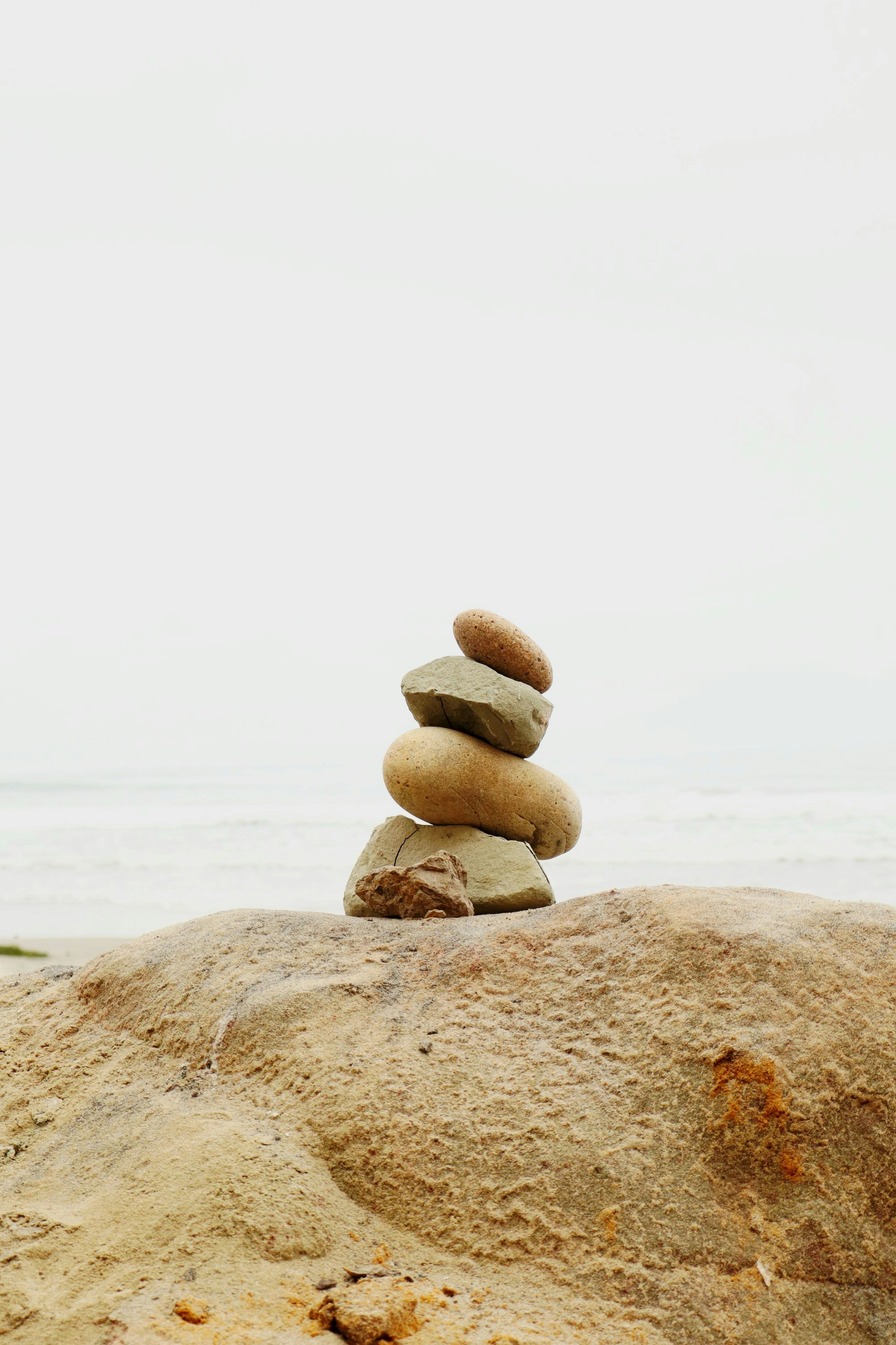 Stacked stones on a beach with ocean background