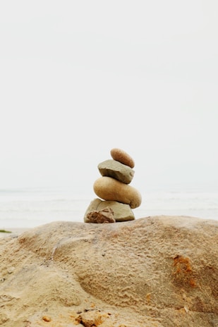 Stacked stones on a beach with ocean background