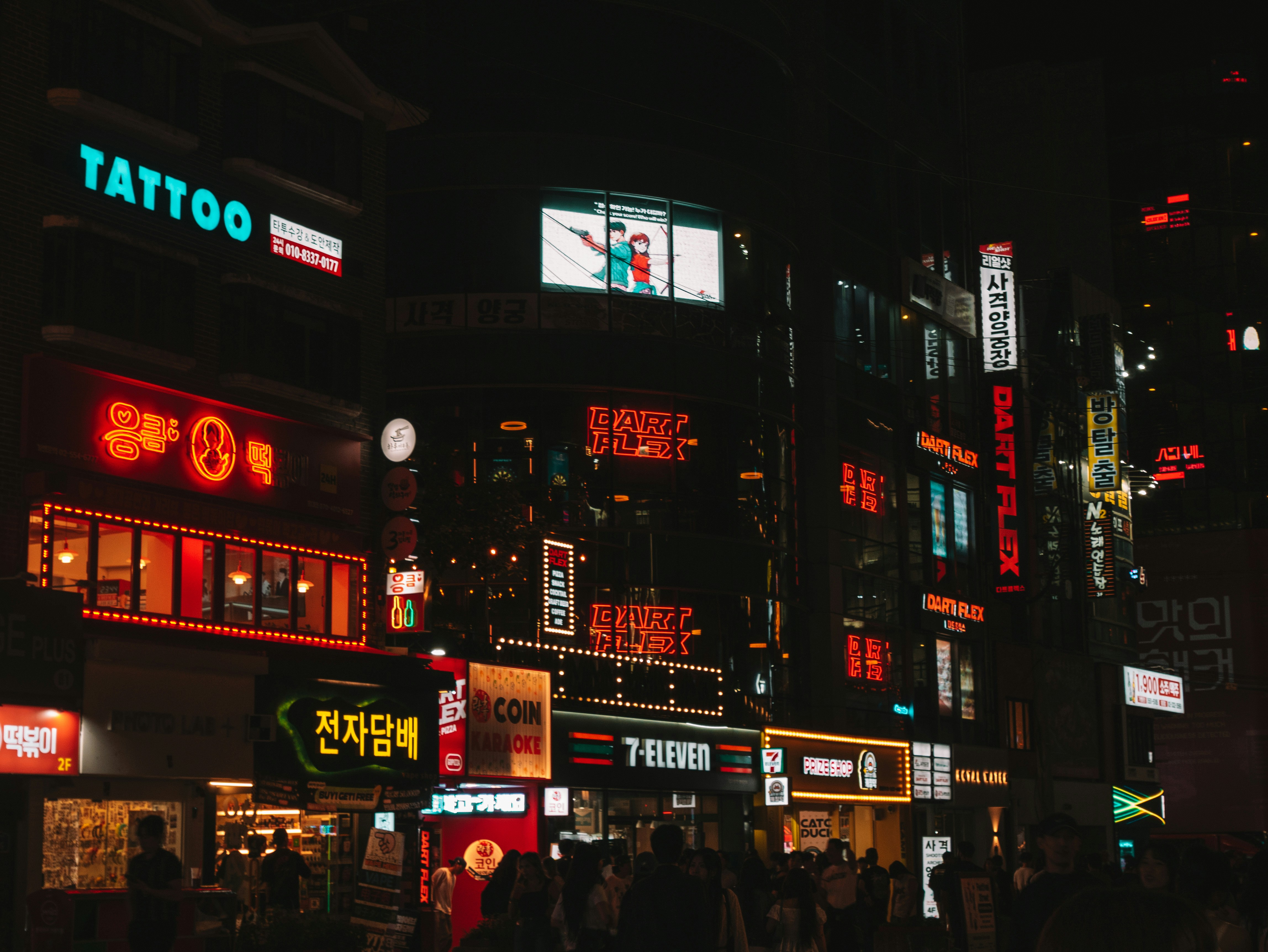 City street at night with glowing neon signs.