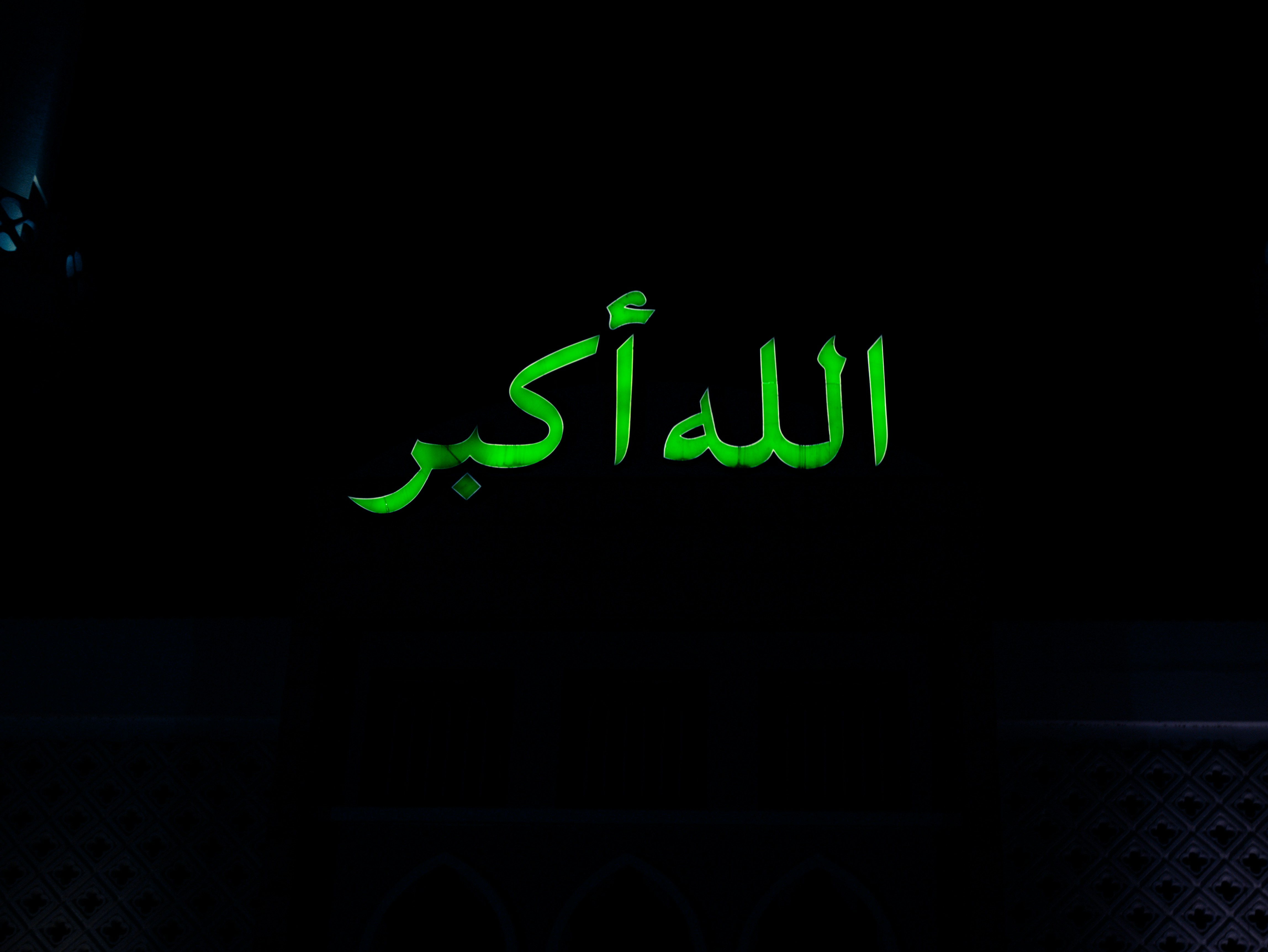 Green arabic text on black background