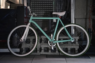 A light blue bicycle with a white seat.