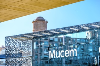 Modern building with mucem logo reflecting sky