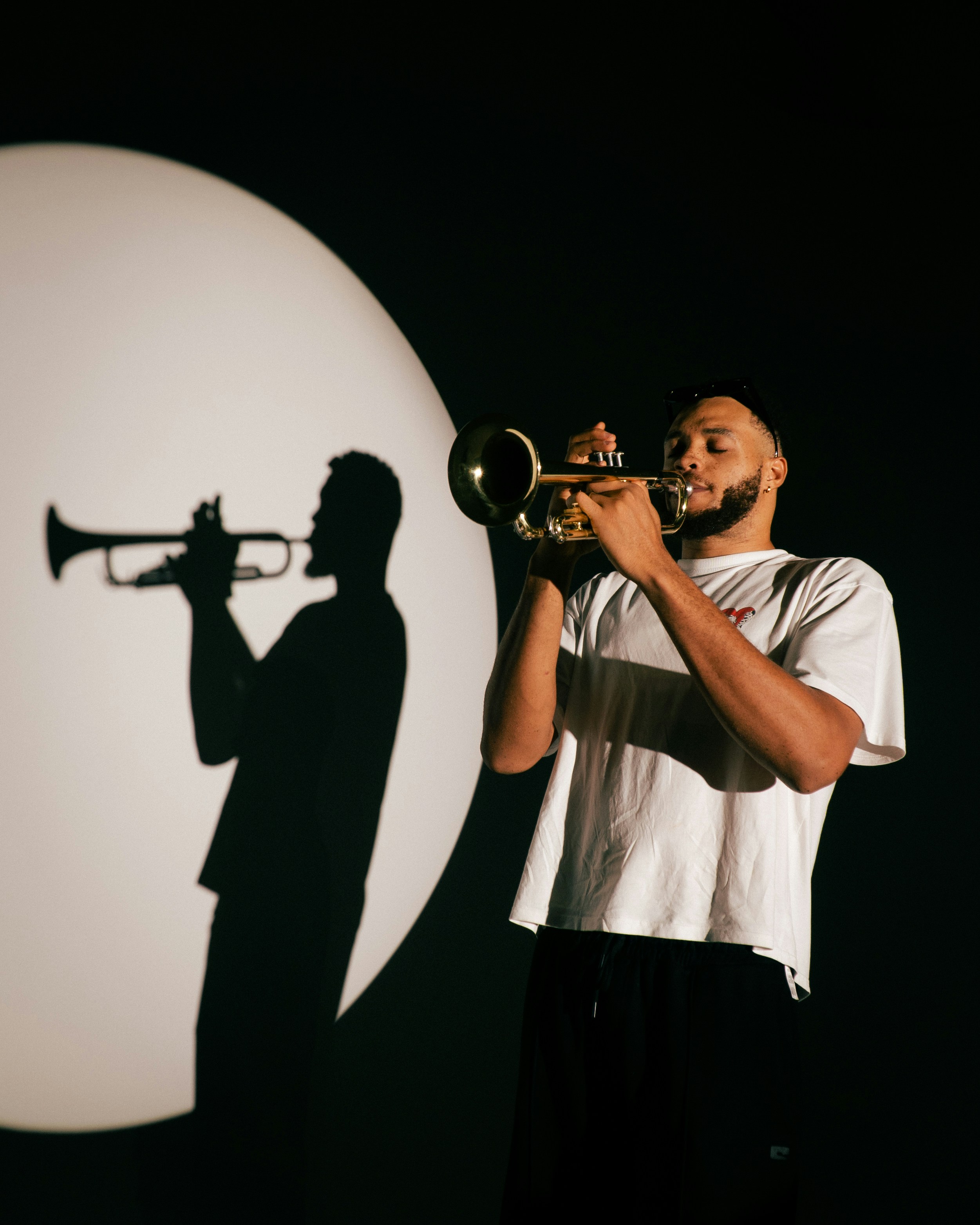 Man playing trumpet with shadow on-stage shadow
