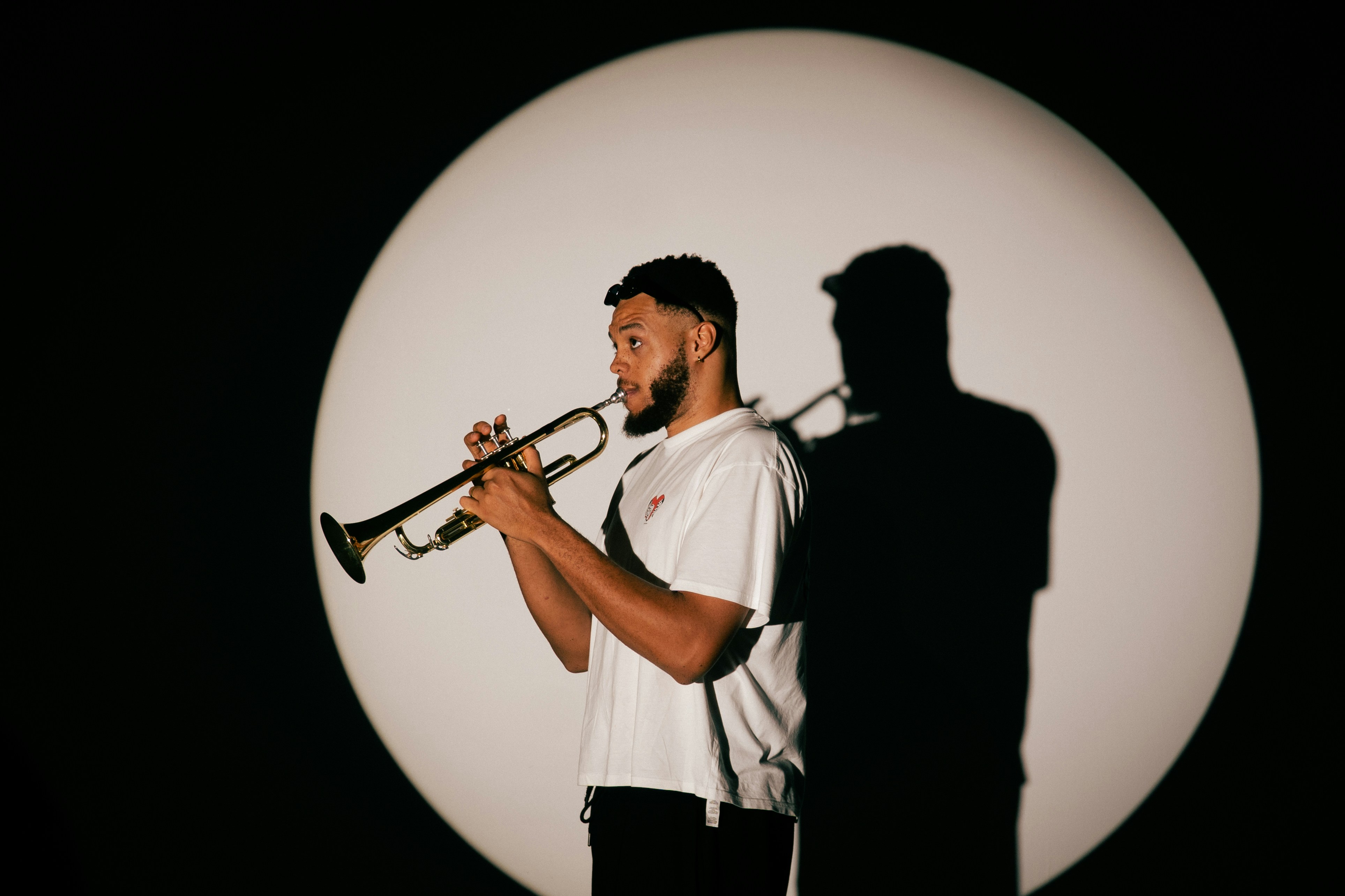 Man playing trumpet with shadow on circle