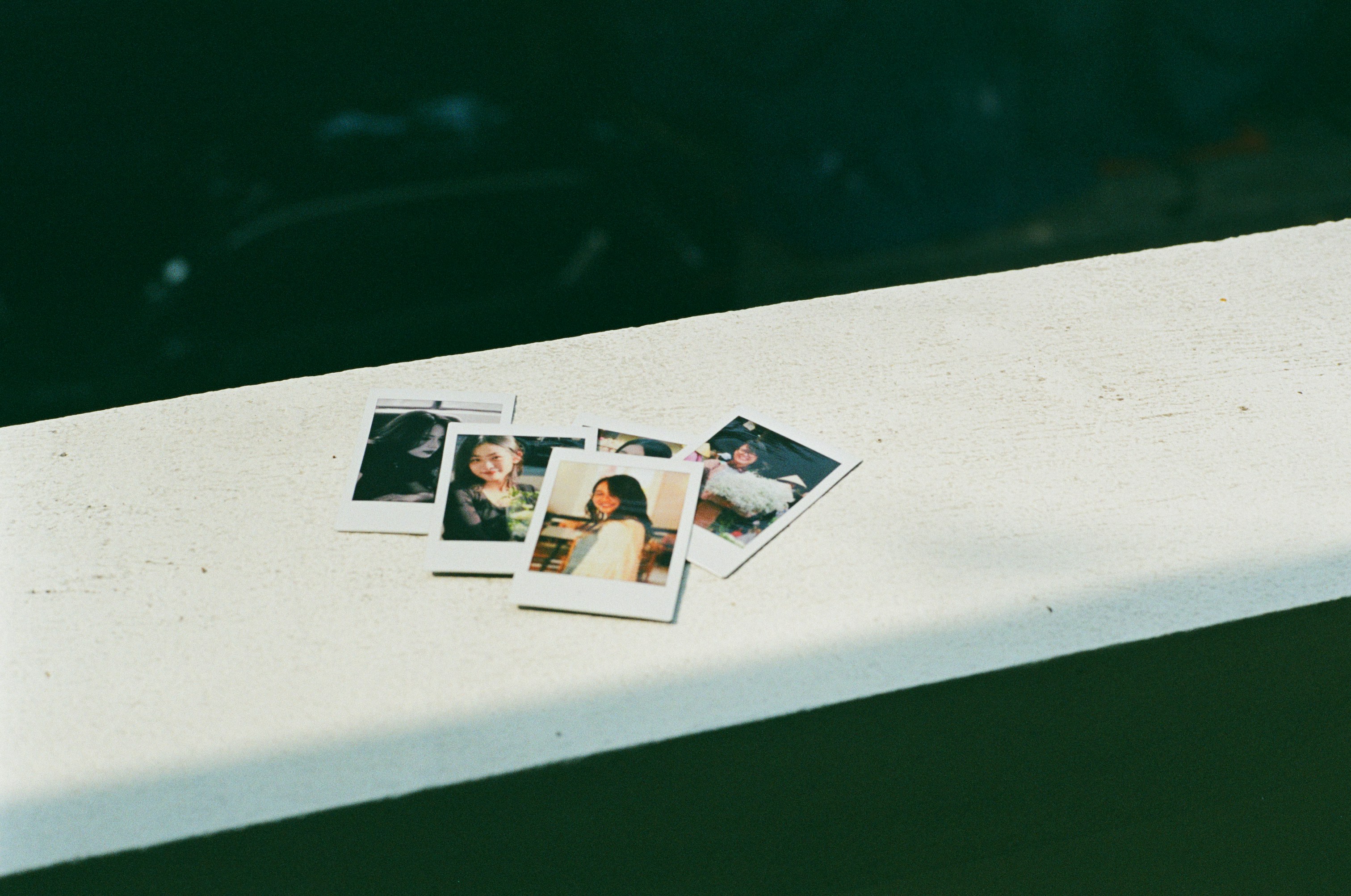 Several instant photos of people on a ledge.