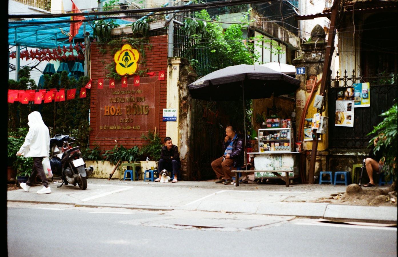People sitting outside a shop with a motorbike