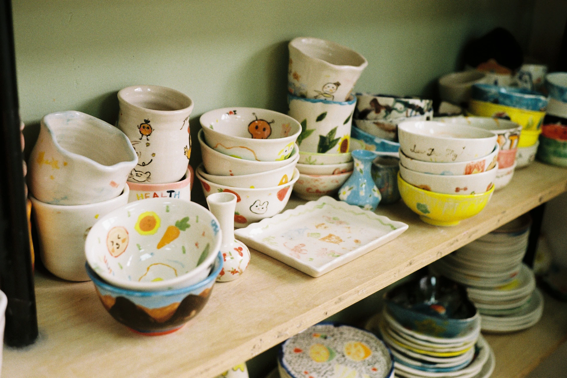 Assortment of handmade ceramic bowls and dishes on shelves.