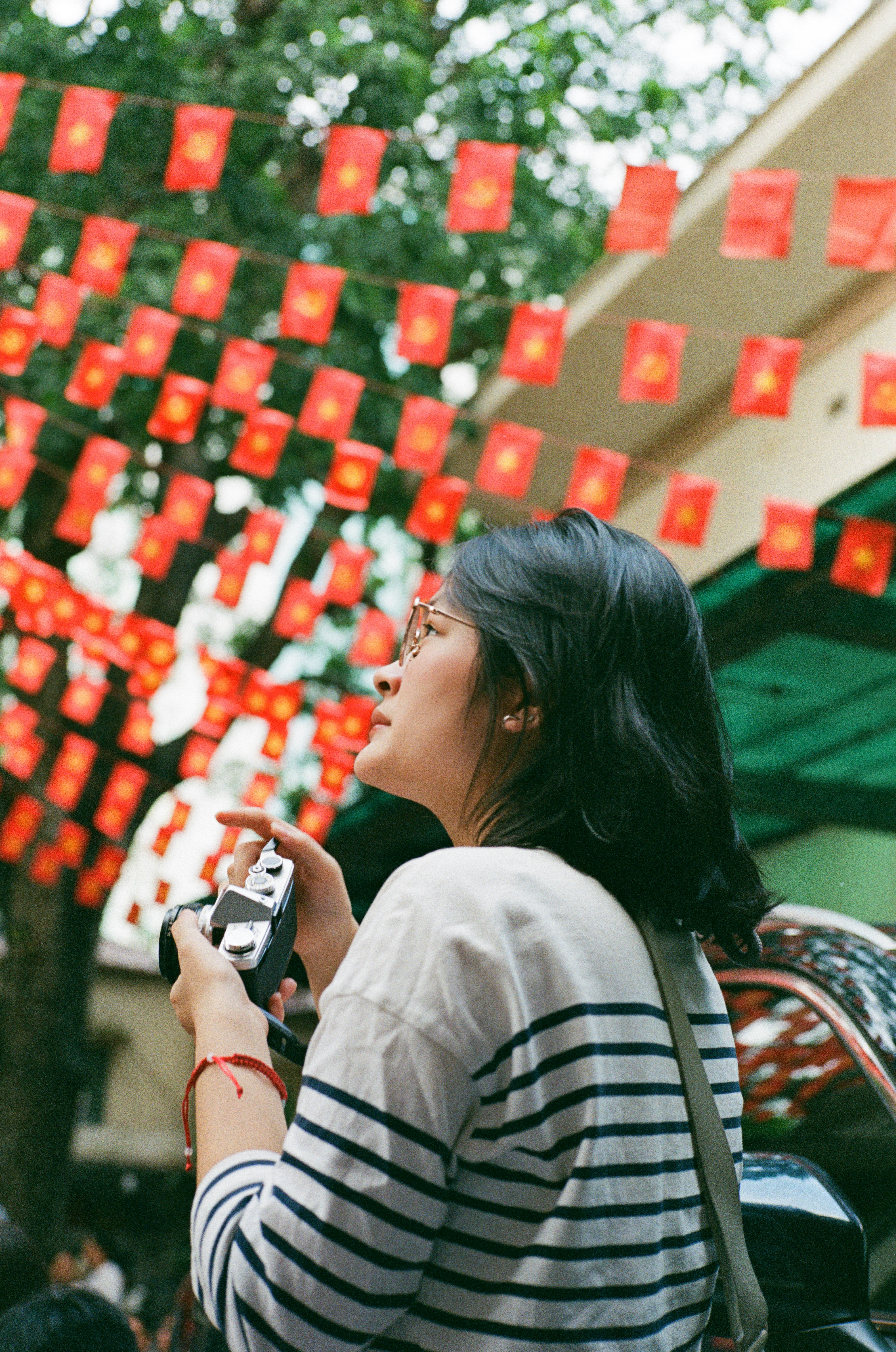 Woman holding camera with red flags overhead photo – Free Photographer ...