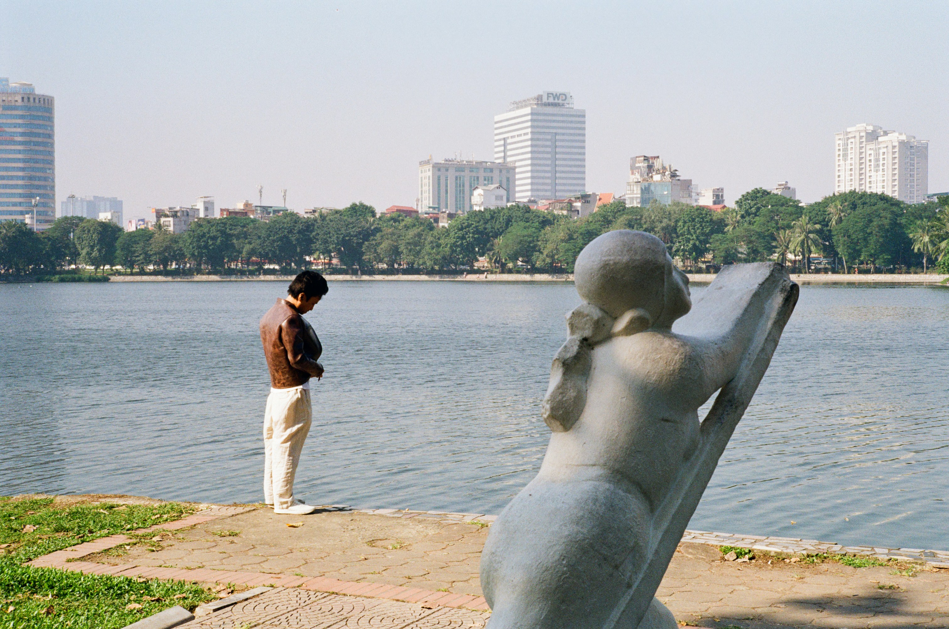 Man standing by lake with city skyline background