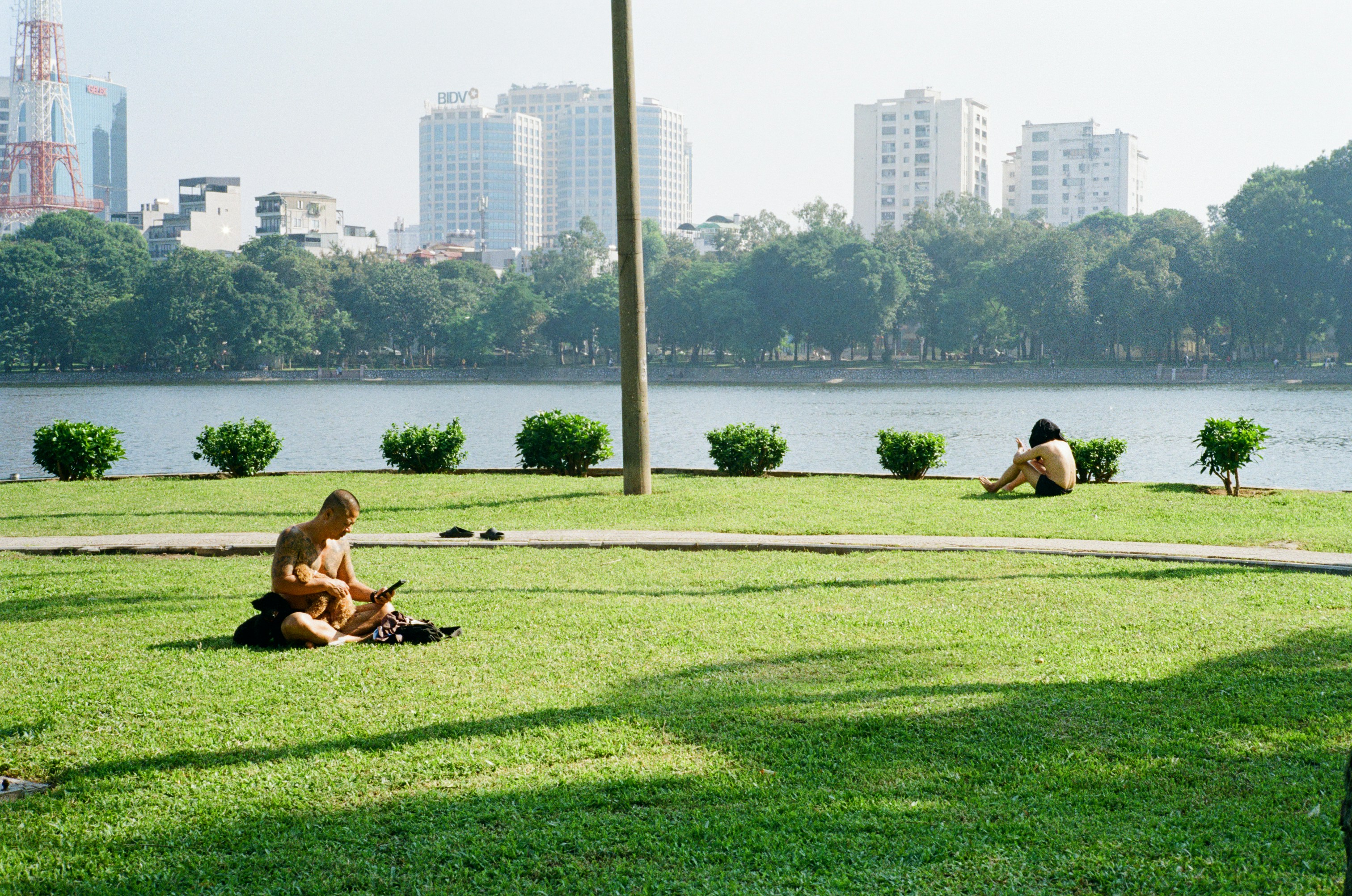 Two men relaxing on grass by a lake