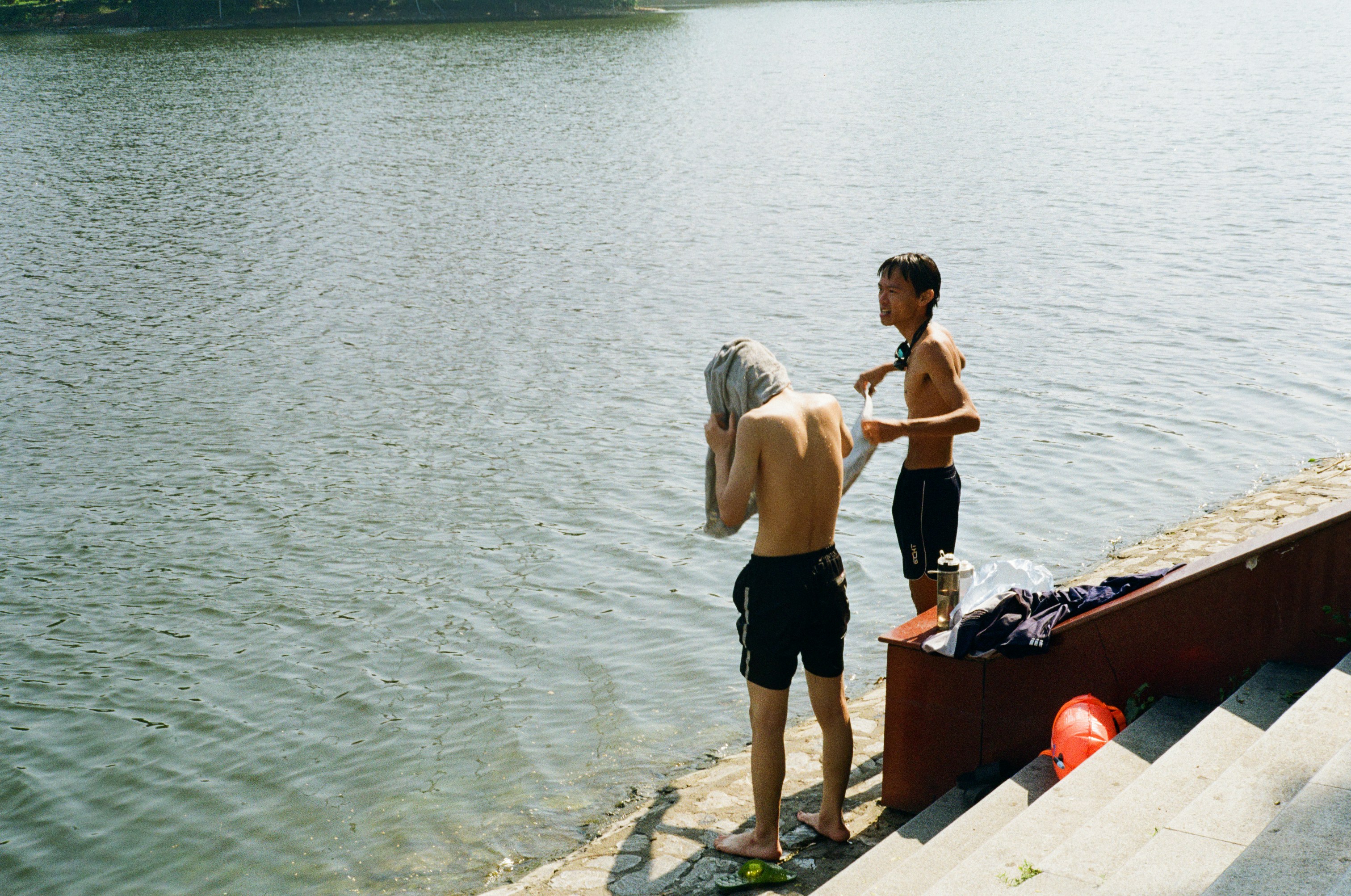 Two boys by the water after swimming