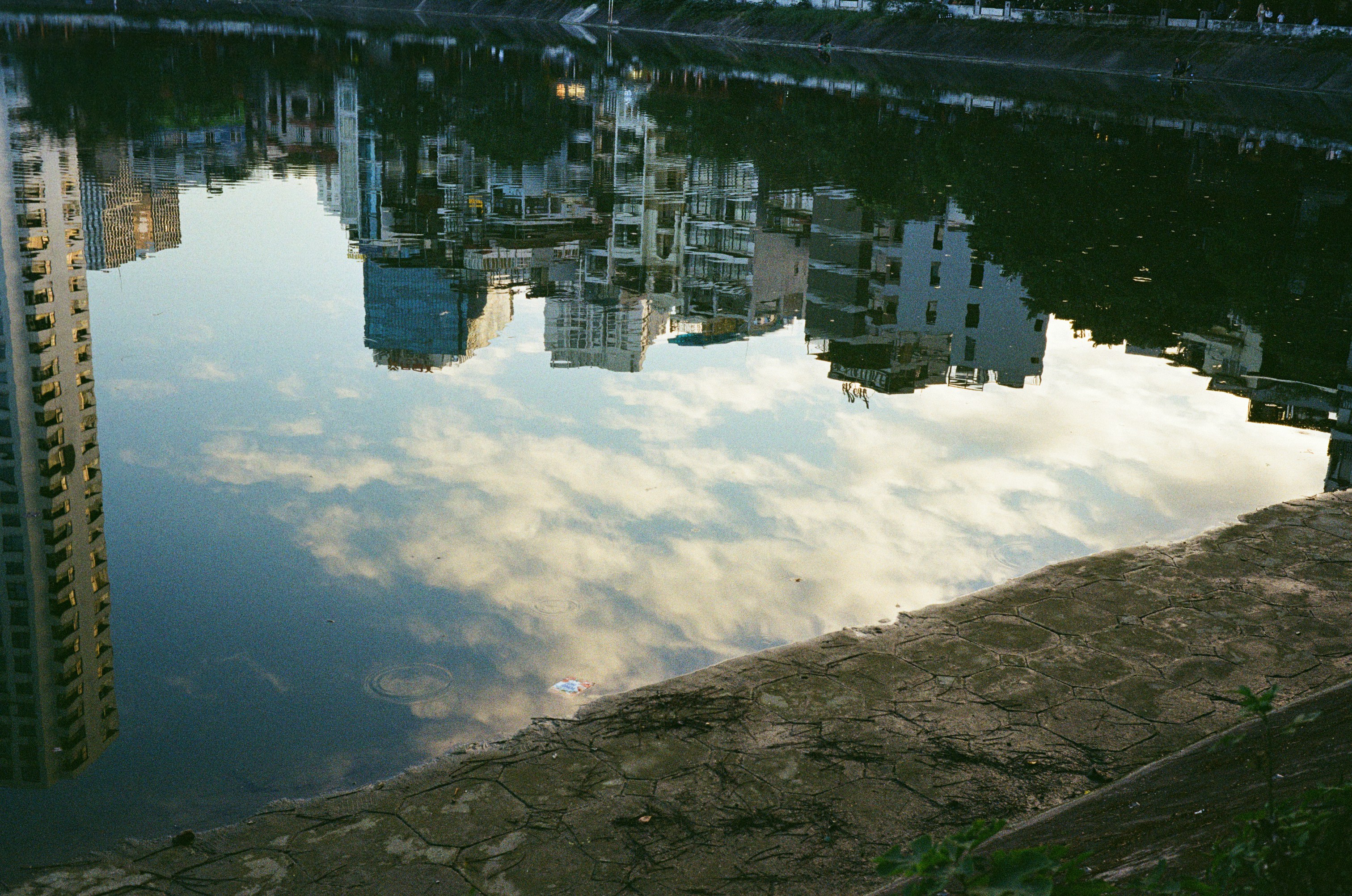 Buildings reflected in calm water at sunset