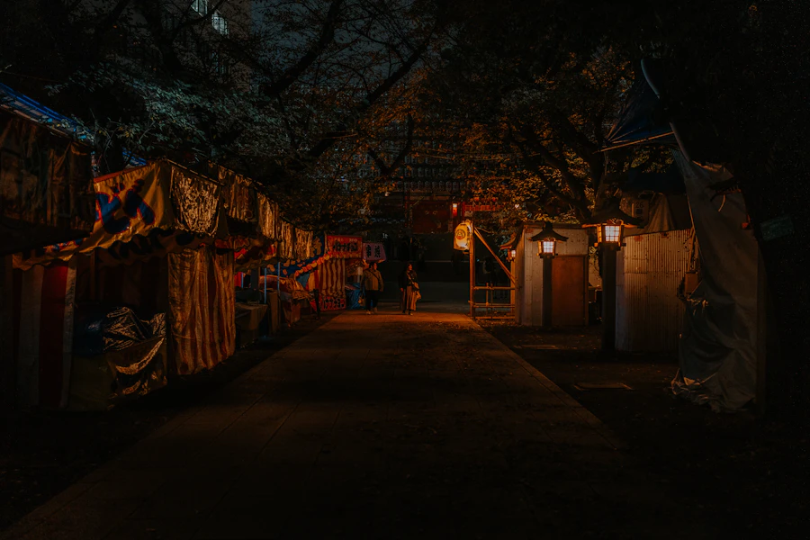 Row of illuminated Japanese food stalls at a summer festival at dusk