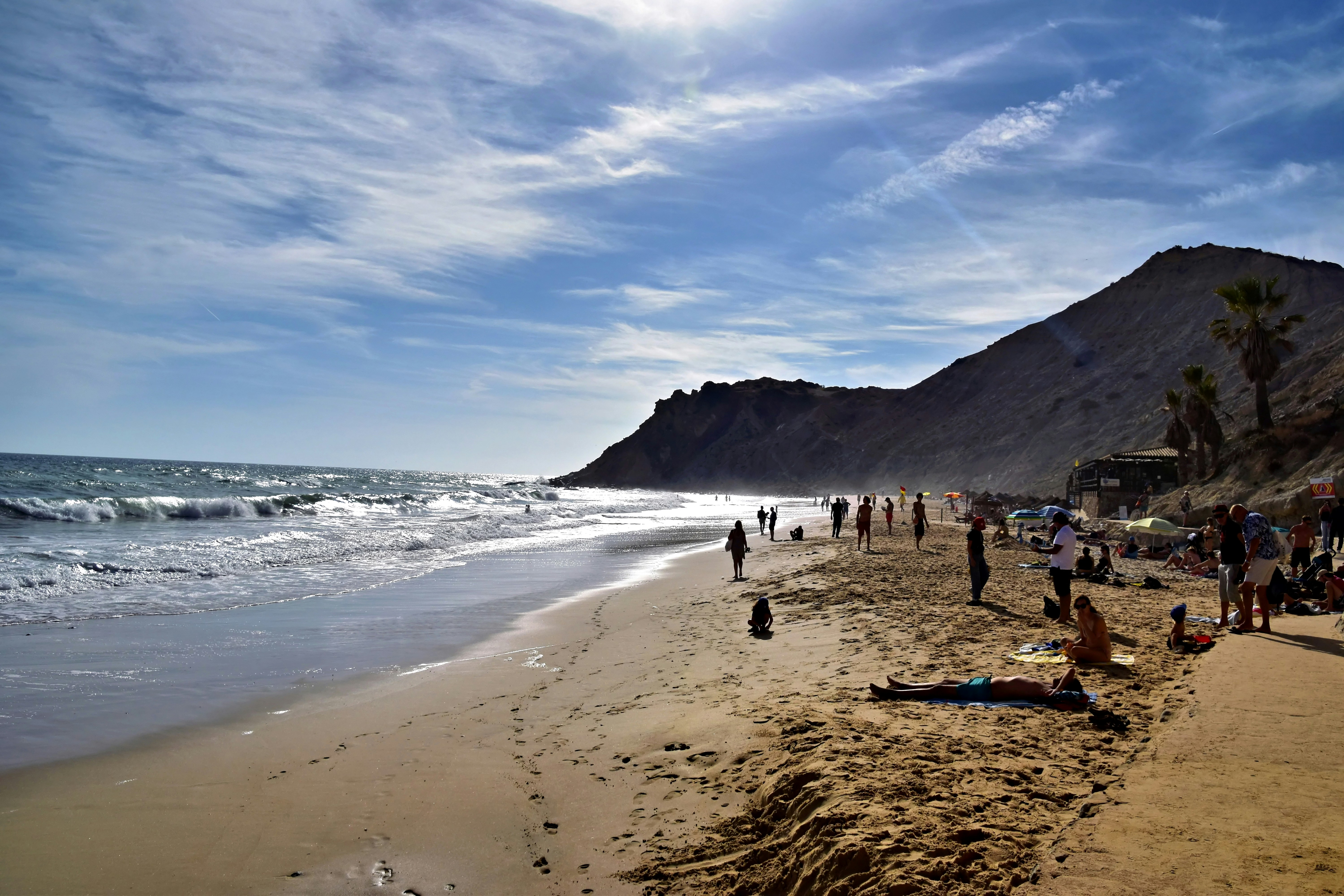 People relaxing on a sandy beach with ocean waves.