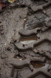 Стъпка, отпечатана в мокра, кална градинска почва след пролетен дъжд.