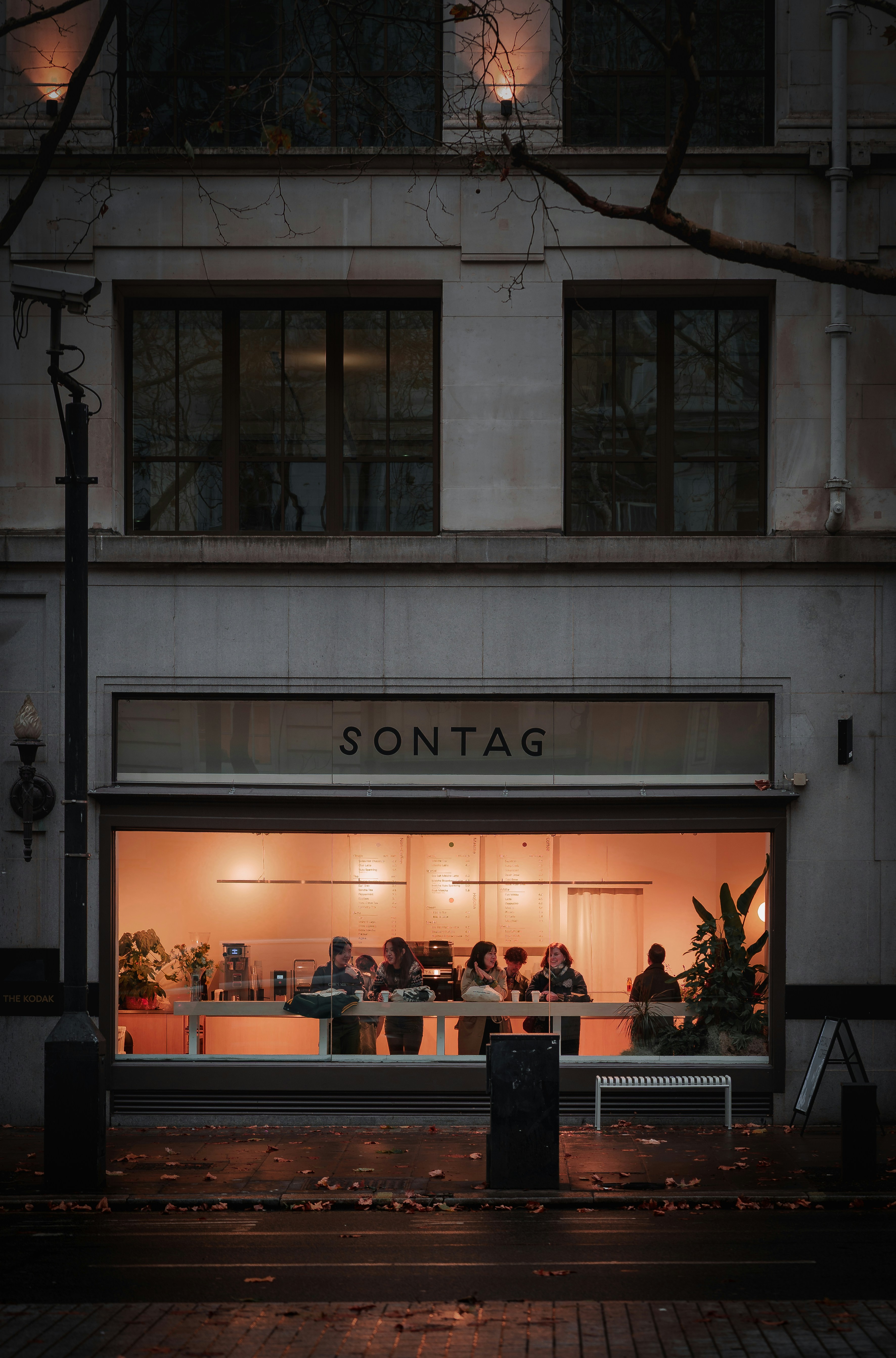 People gathered inside a warmly lit cafe at night