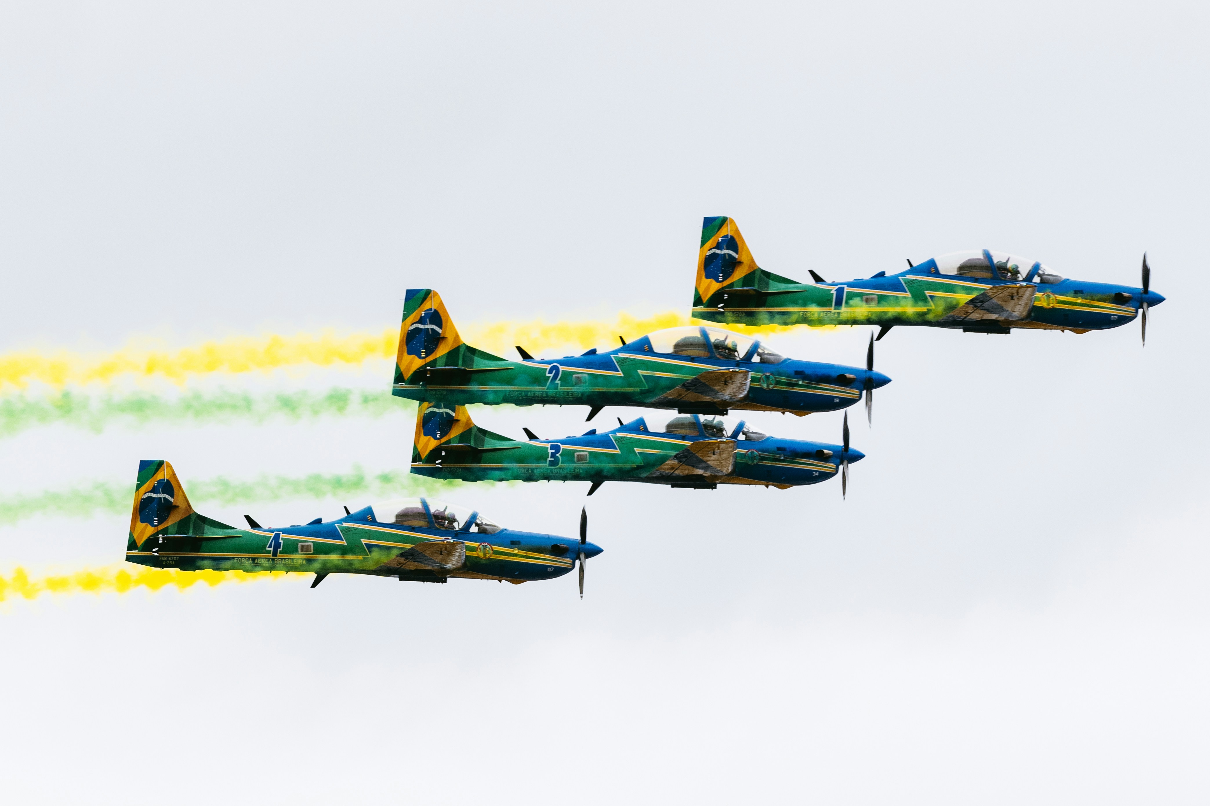 Quattro aerei volano in formazione con scie di fumo colorate