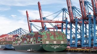Container ship docked at a busy port with cranes