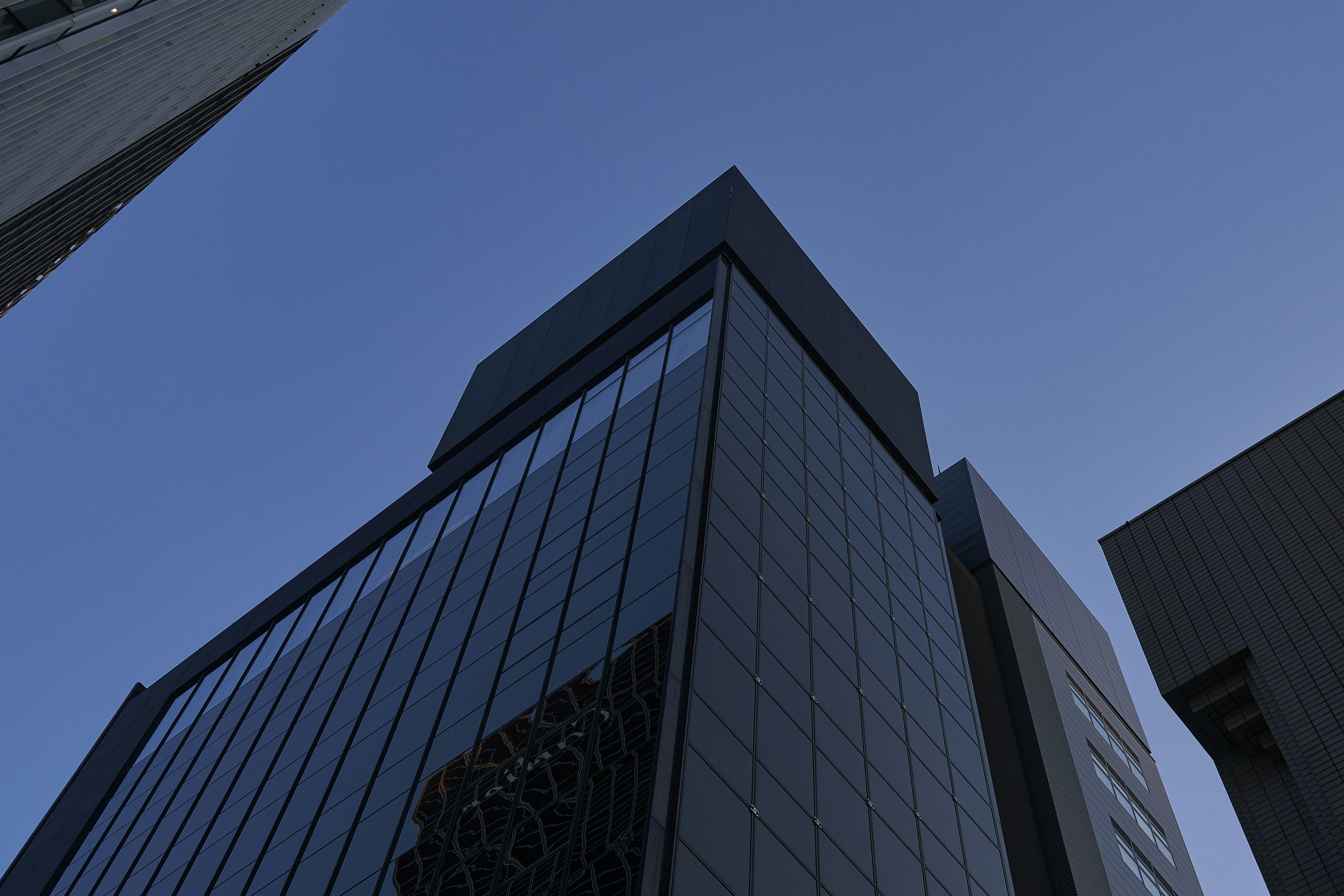 Modern dark buildings against a clear blue sky