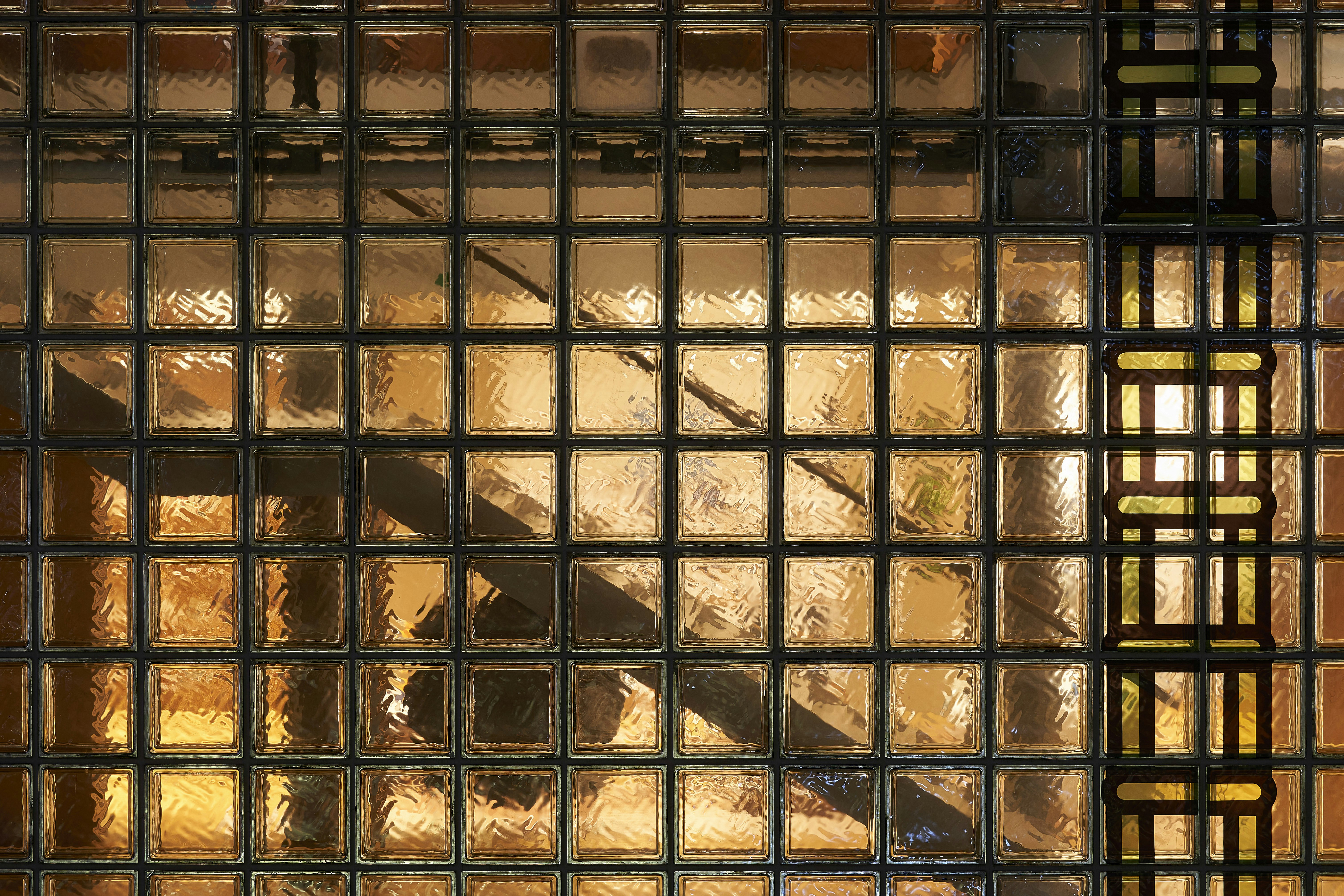 Glass block wall with a staircase behind it.