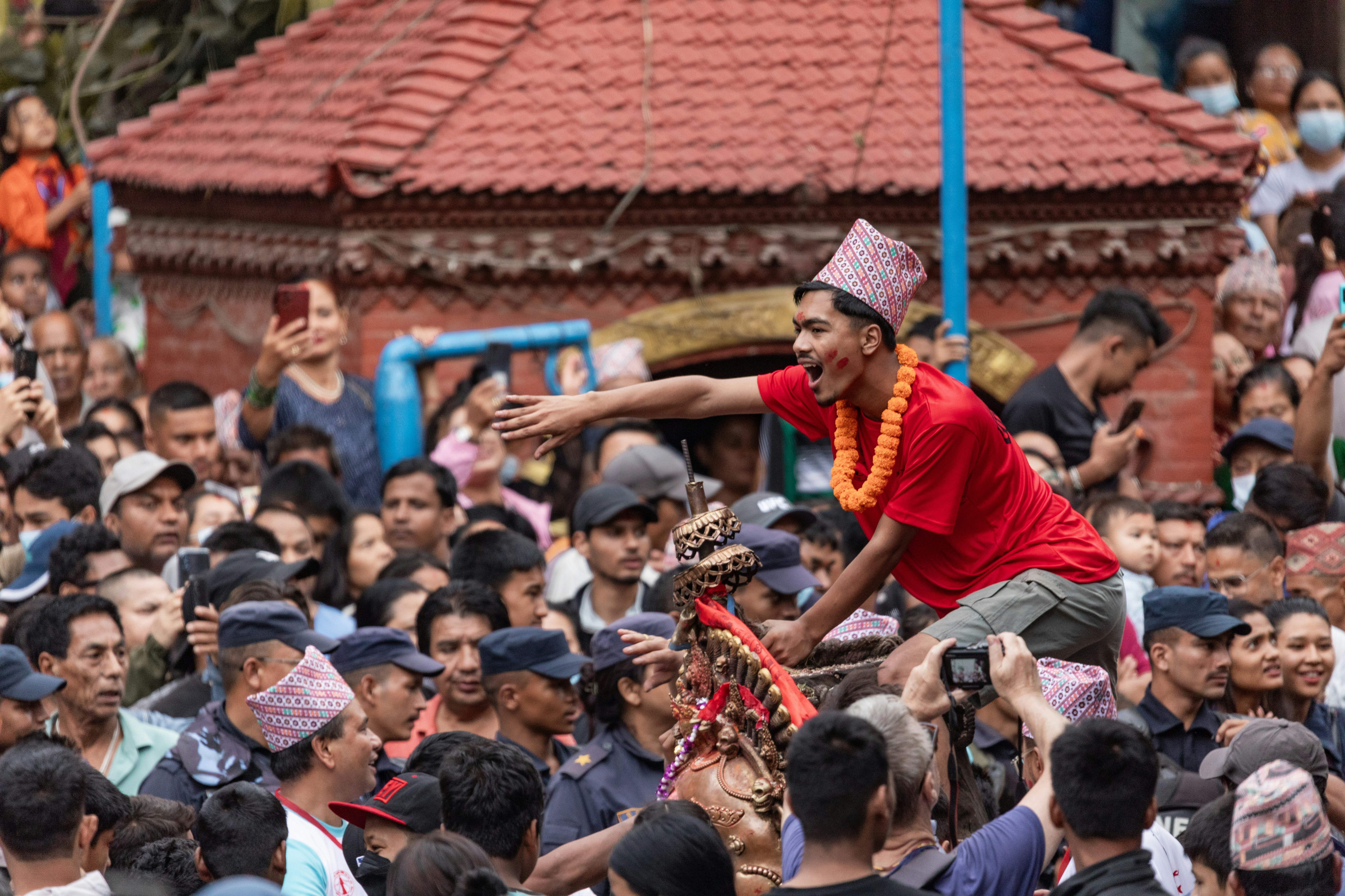 Pria berbaju merah merayakan dengan kerumunan