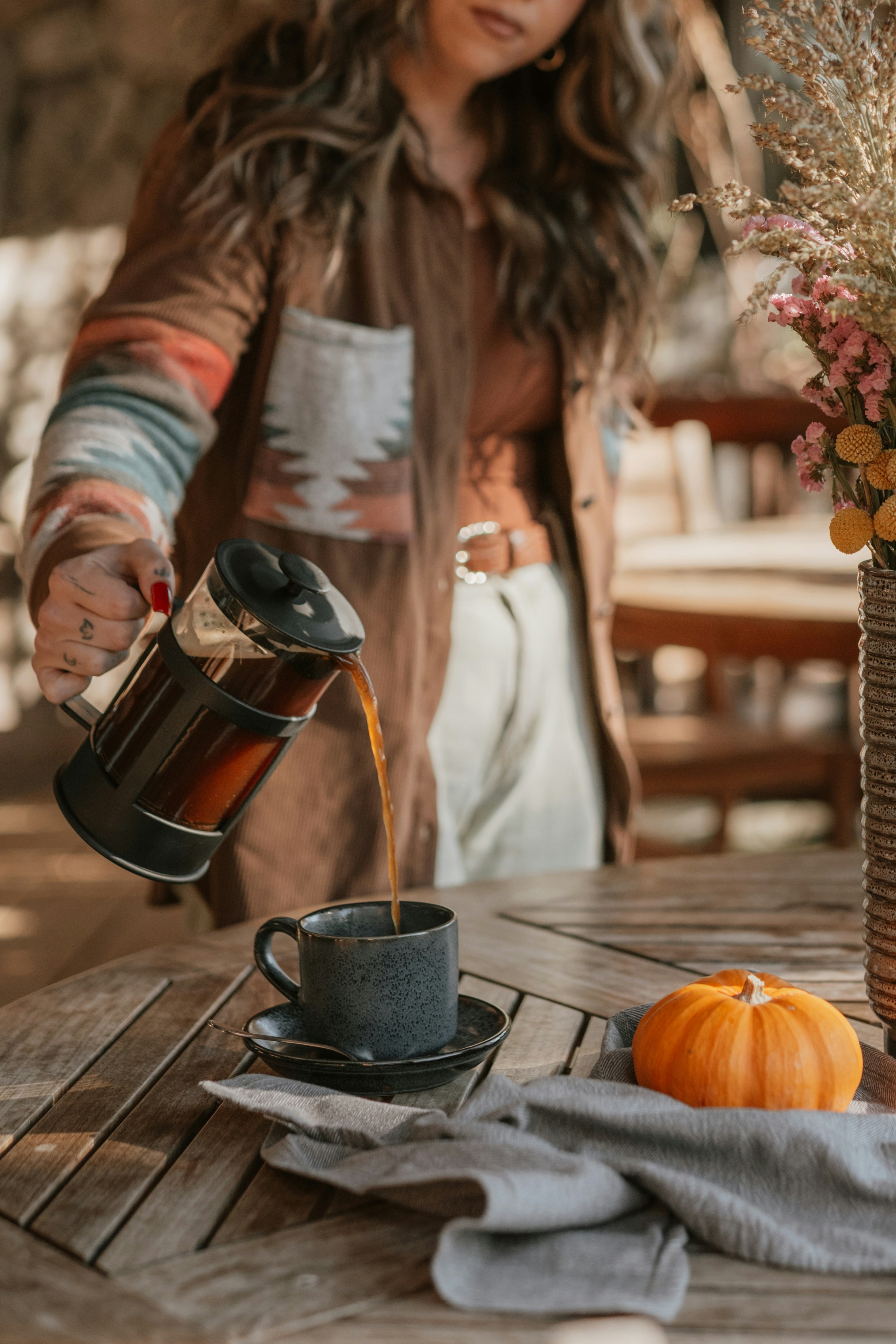 Woman pouring coffee from french press into cup
