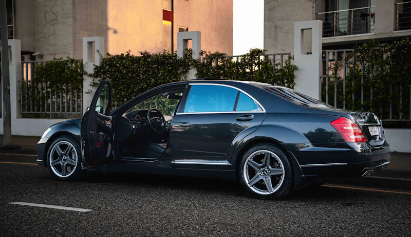 Luxury dark sedan with doors open, inviting a sugar baby