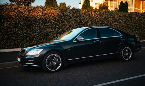 A dark luxury sedan parked on a street.
