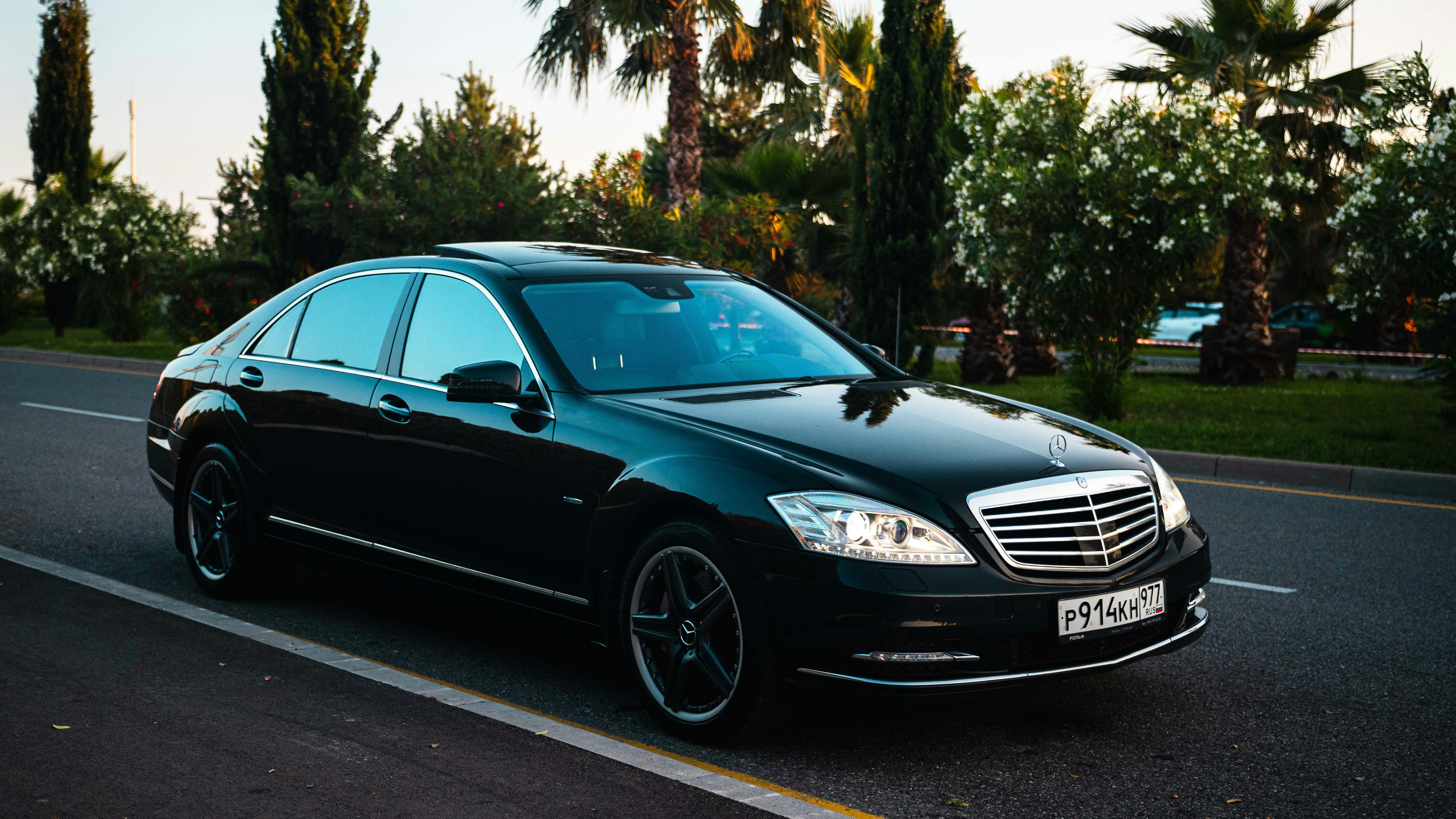 A black luxury sedan parked on a road